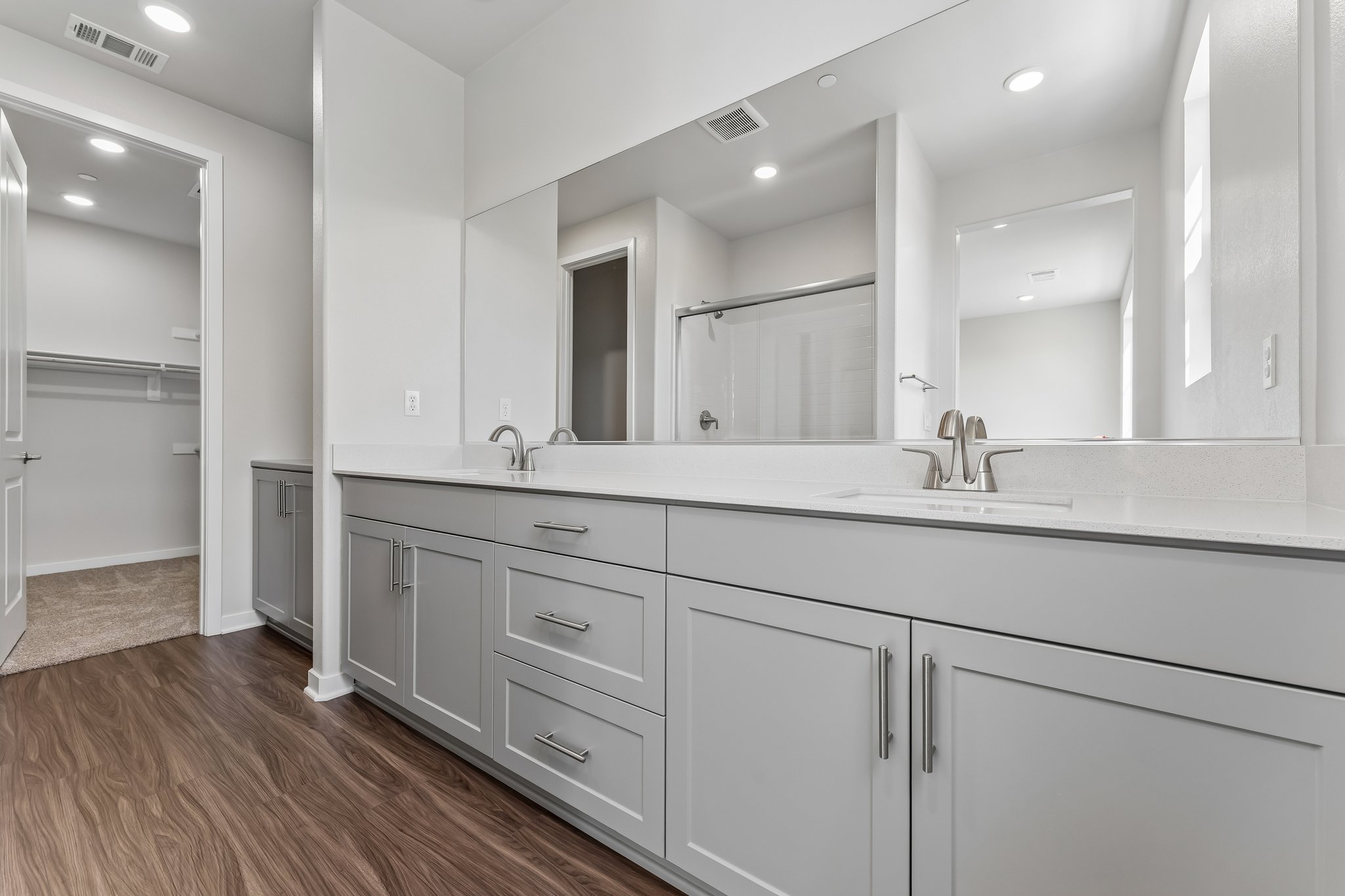 A bathroom with white cabinets.