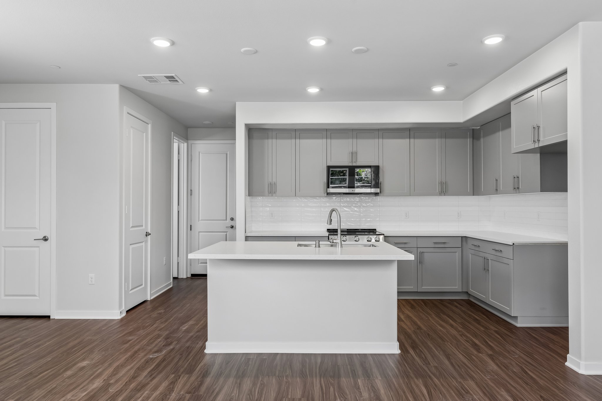A kitchen with white cabinets.