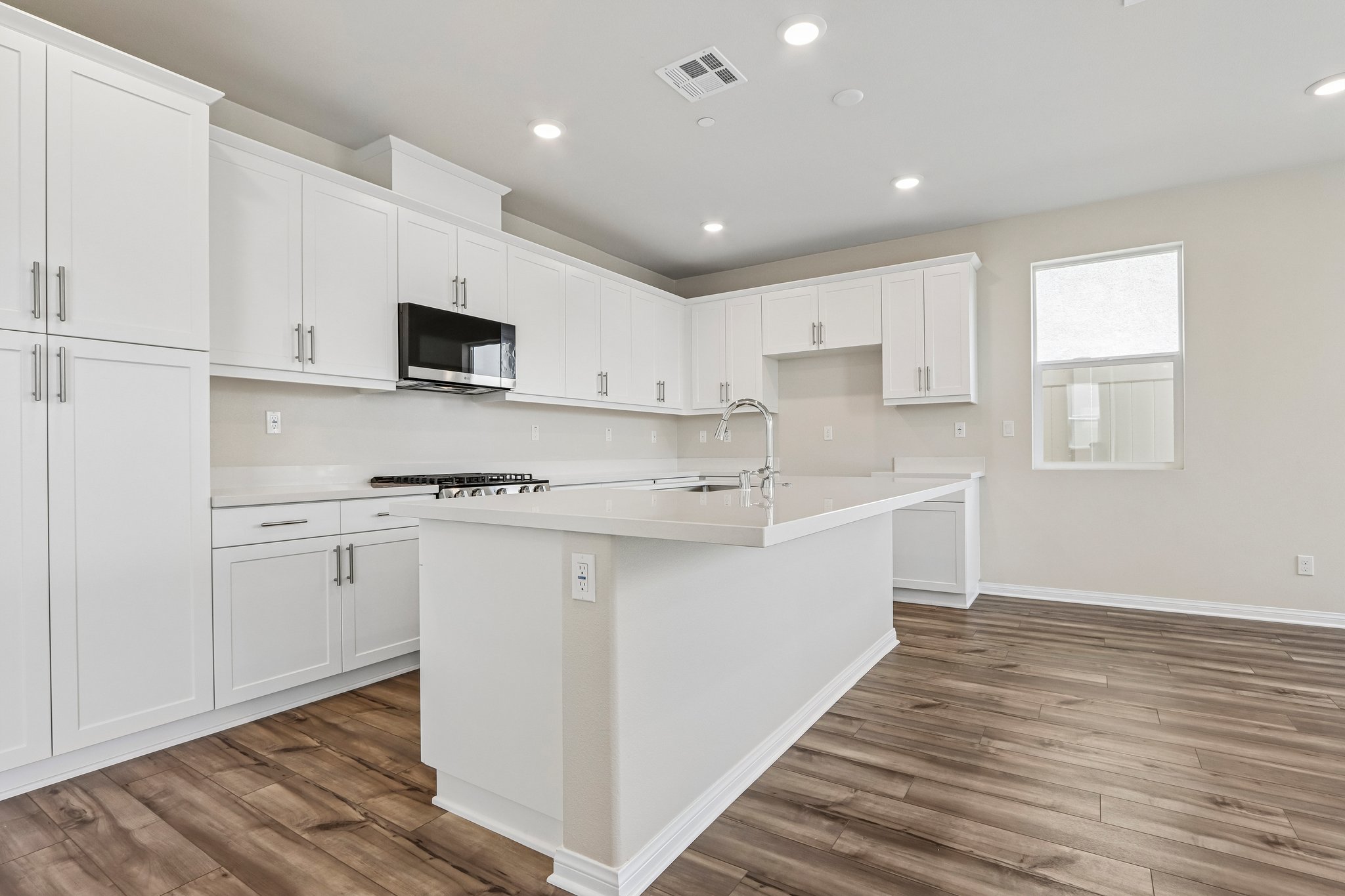 A kitchen with white cabinets.