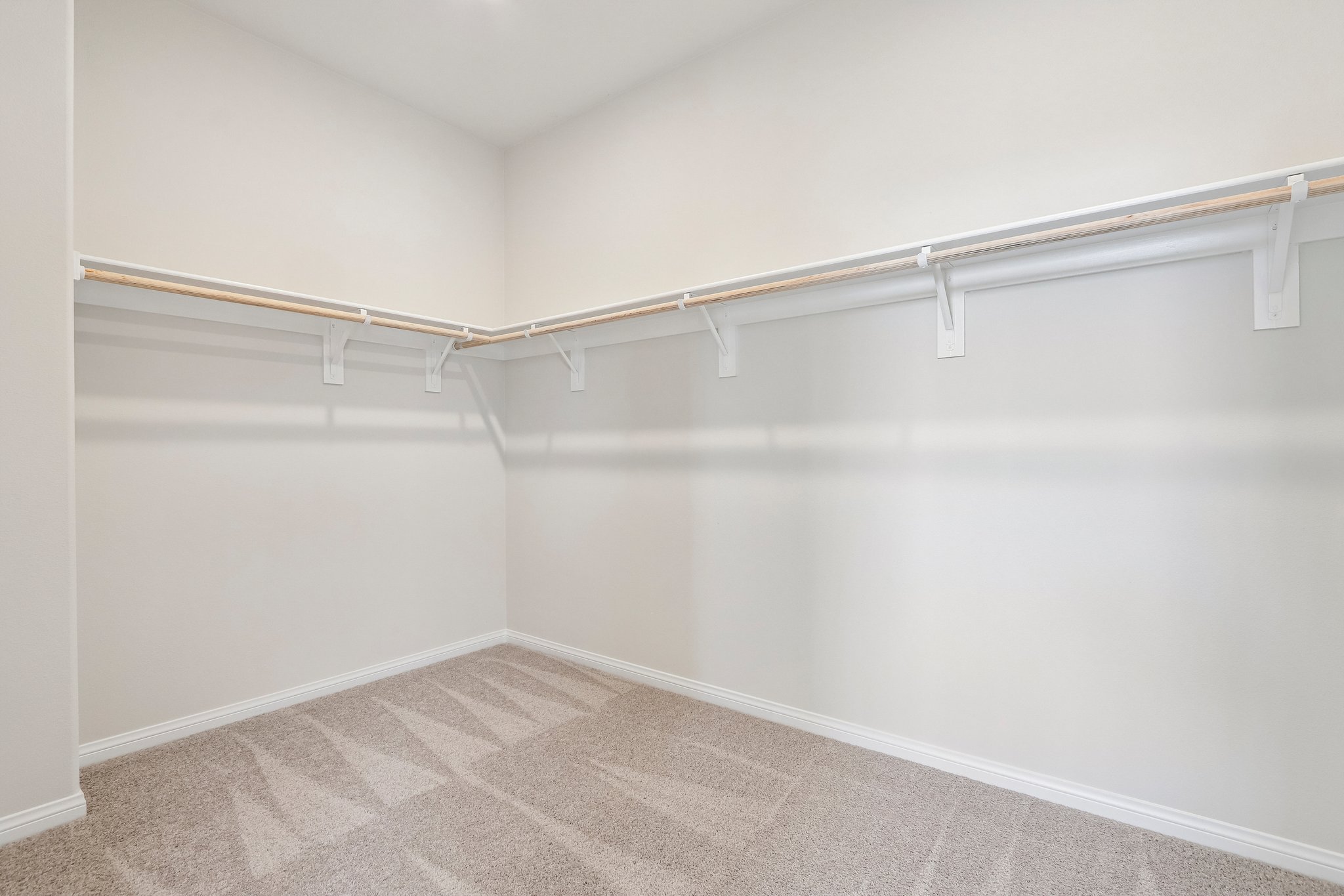 A white wall with a metal bar.