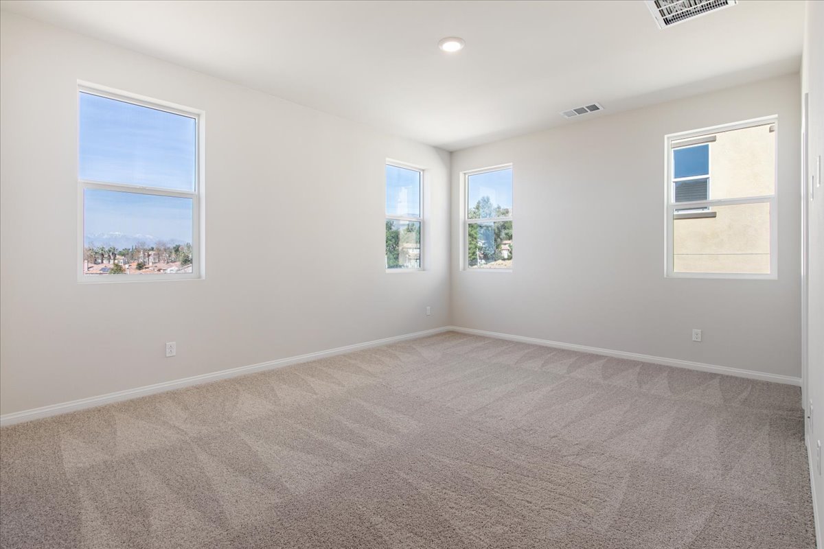 A room with a carpet and windows.