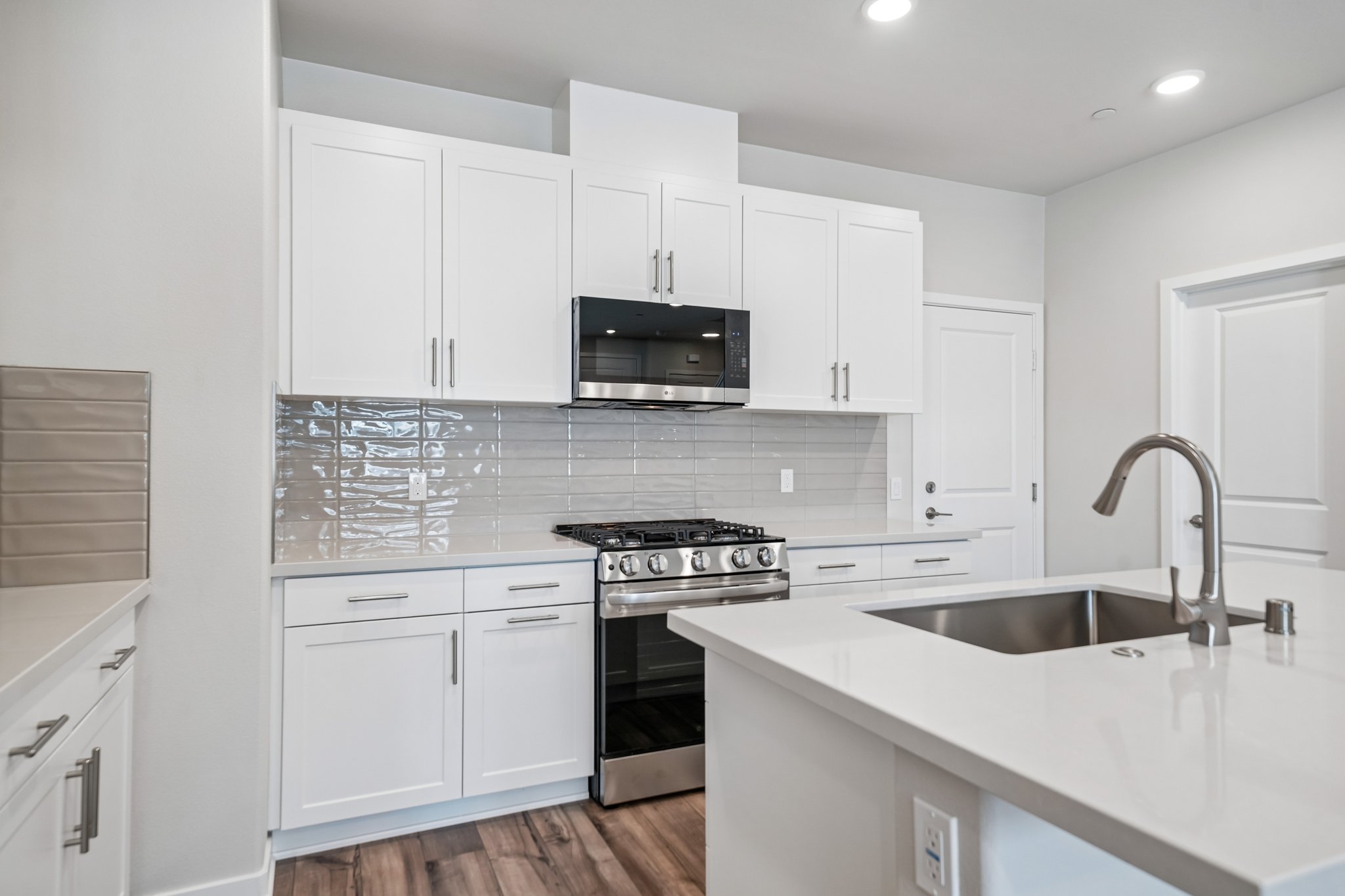 A kitchen with white cabinets.