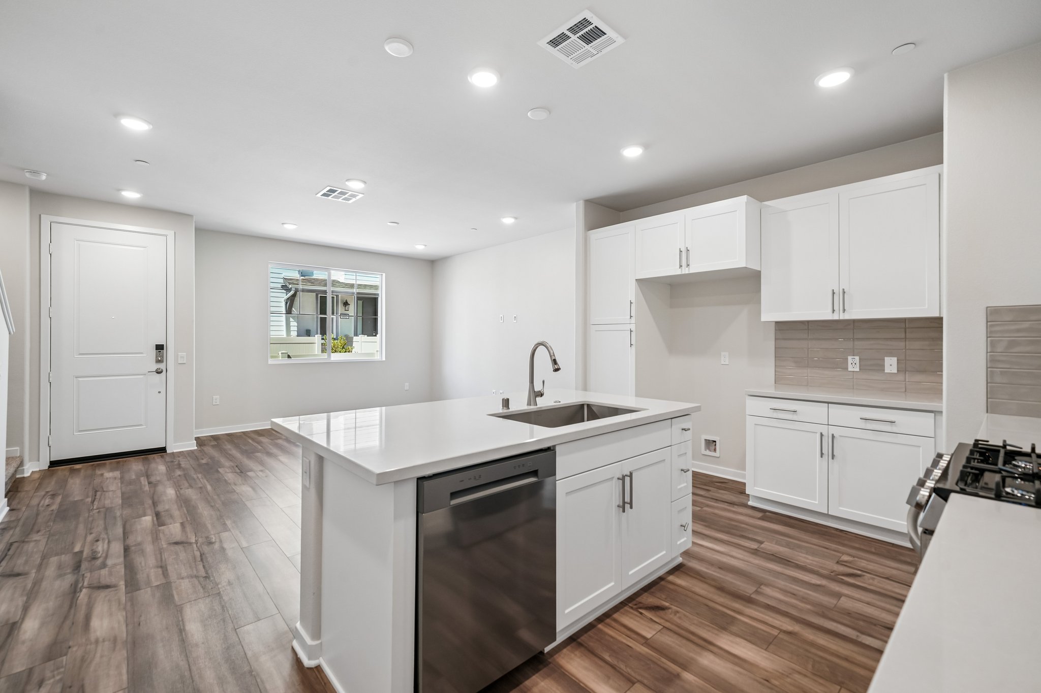 A kitchen with white cabinets.
