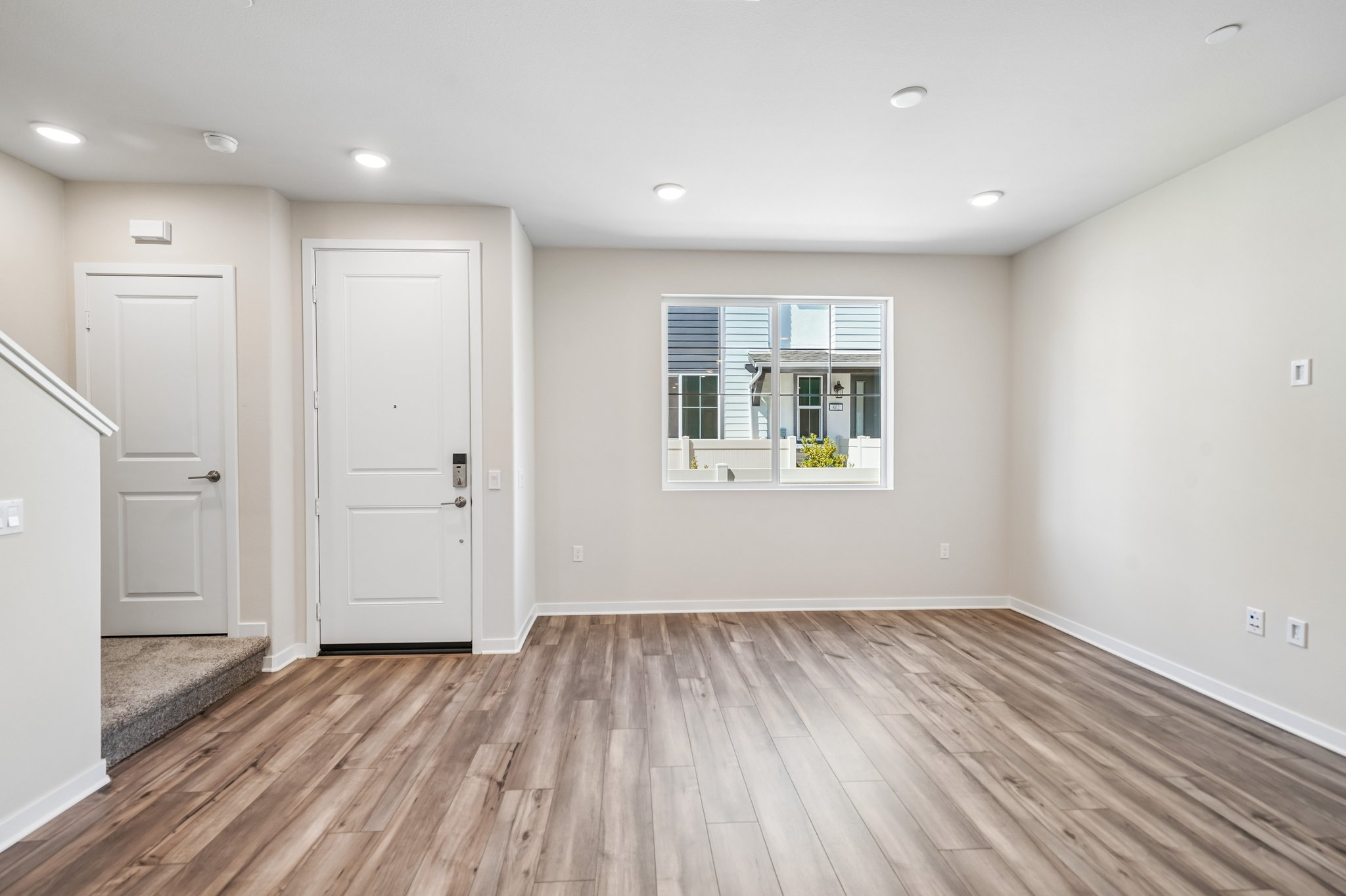 A room with white doors and a wood floor.