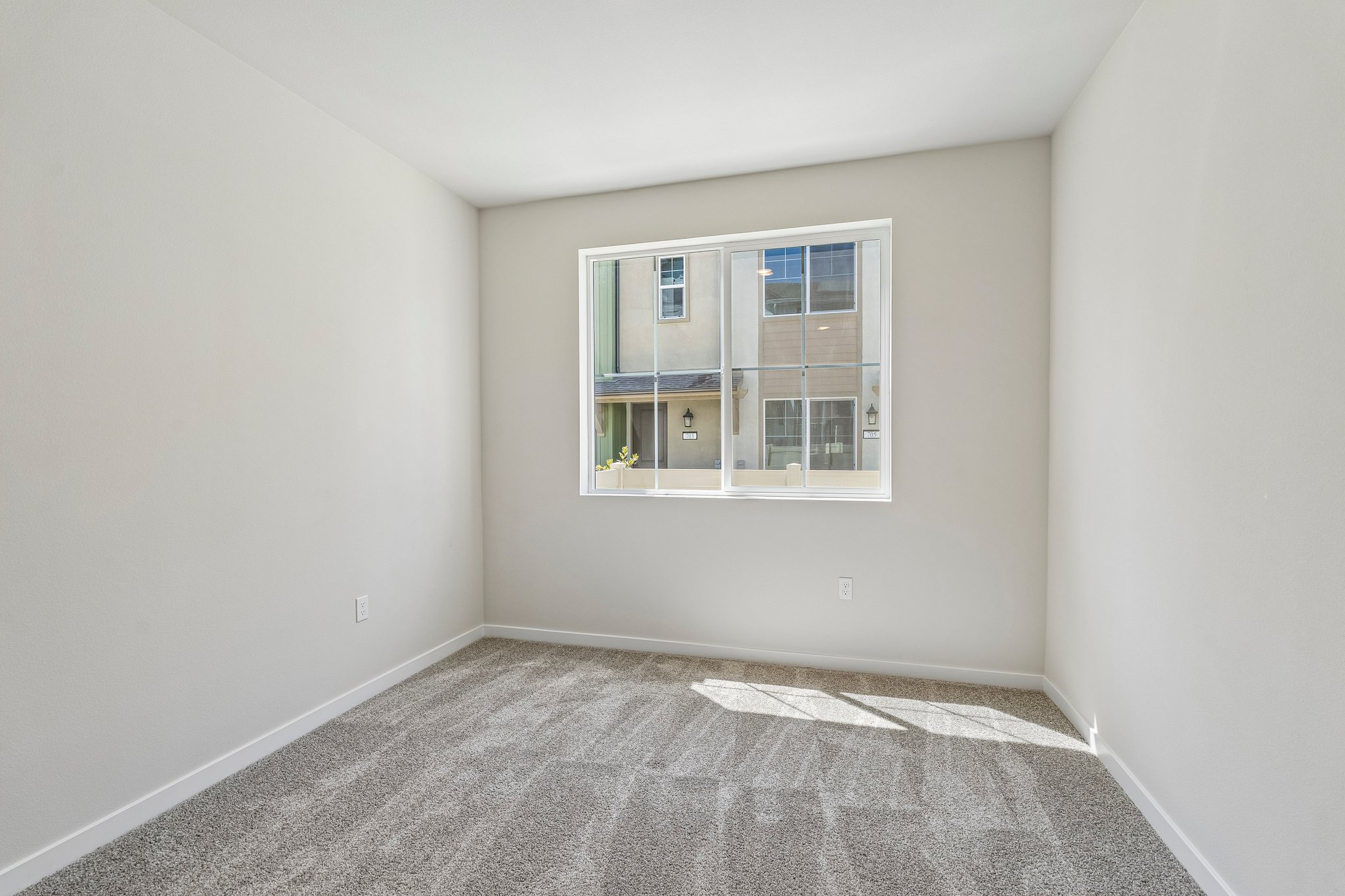 A room with a window and carpet.