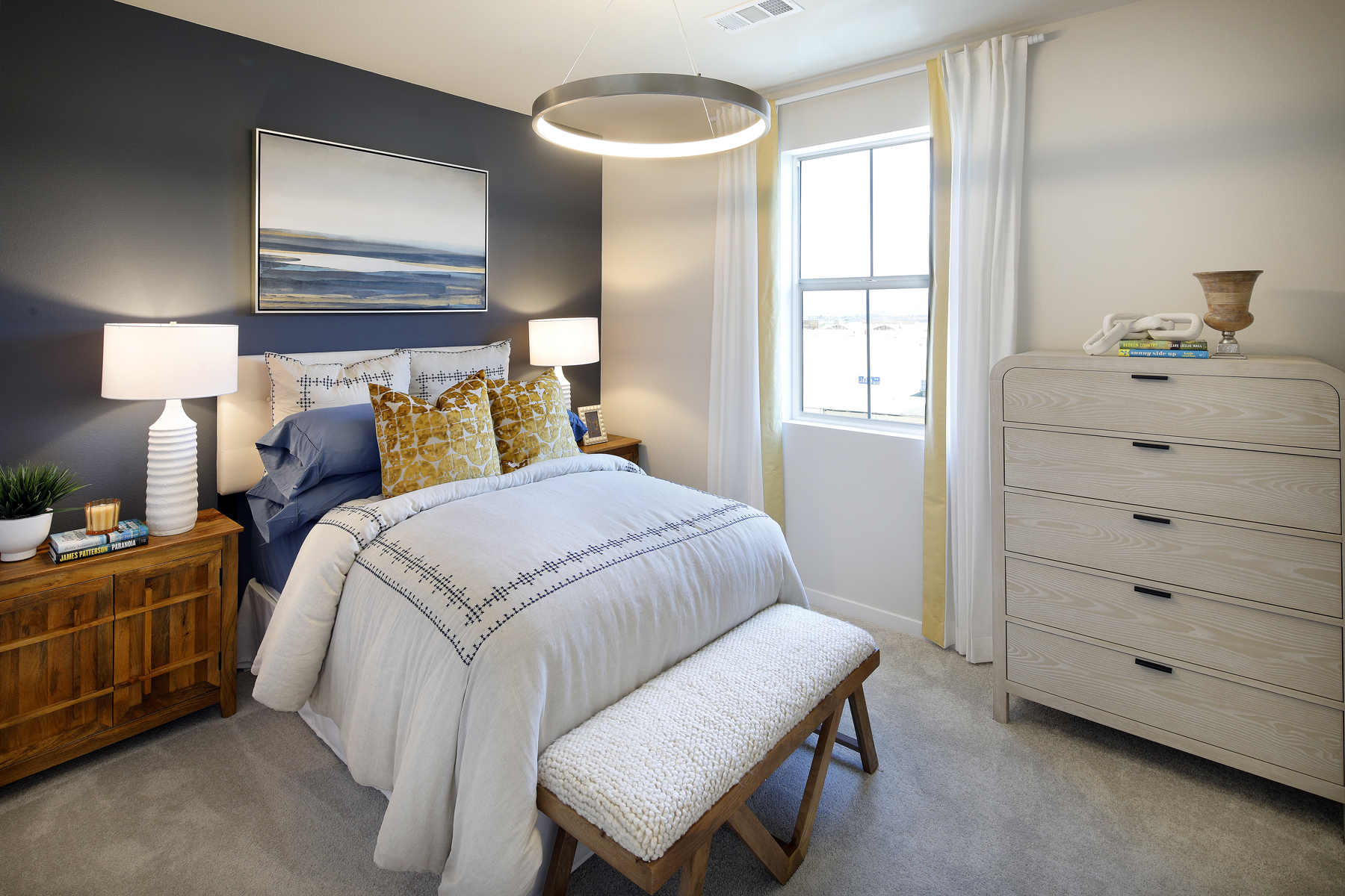 A bedroom with a bed and a bench.