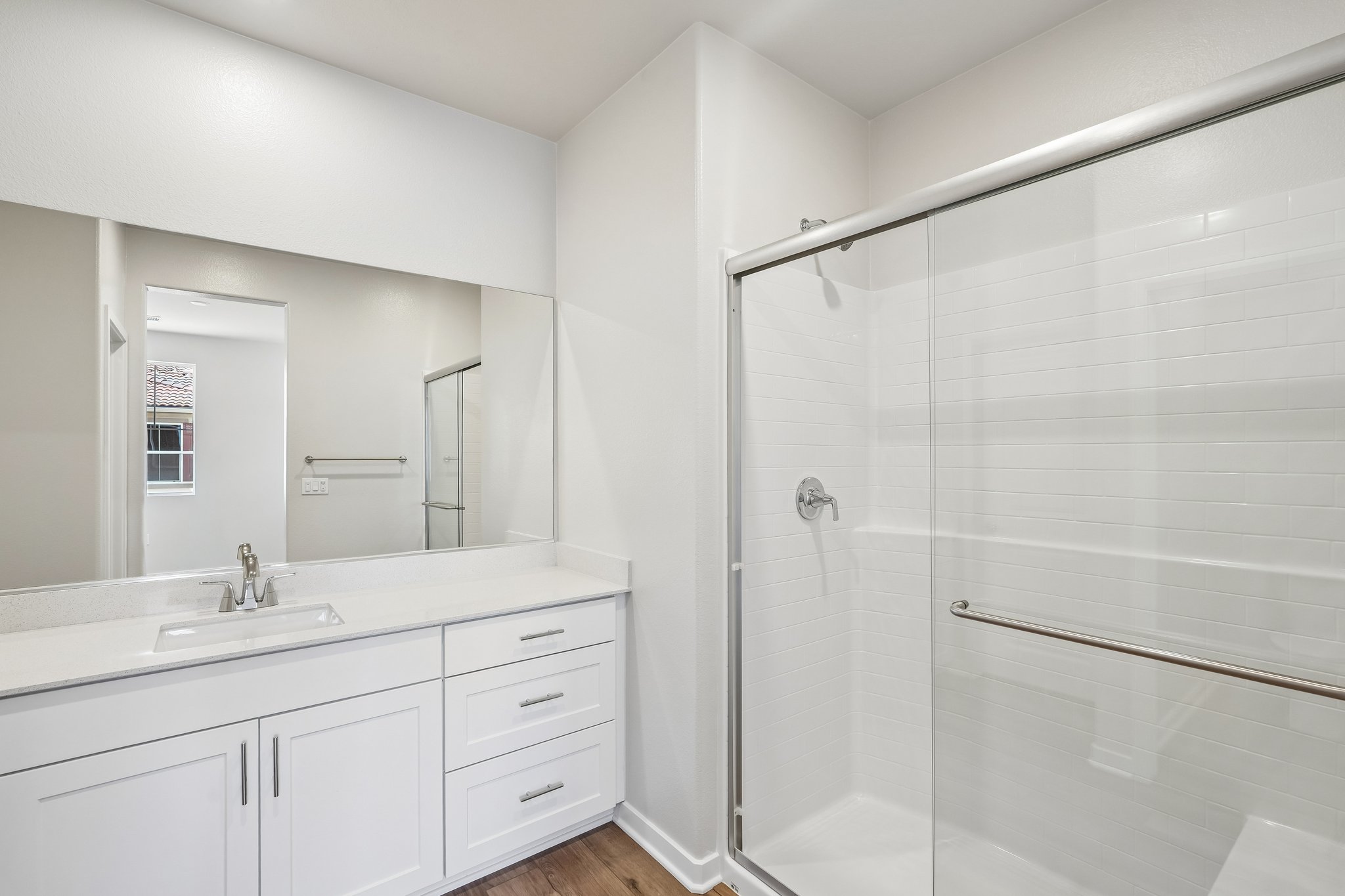 A bathroom with a shower and sink.