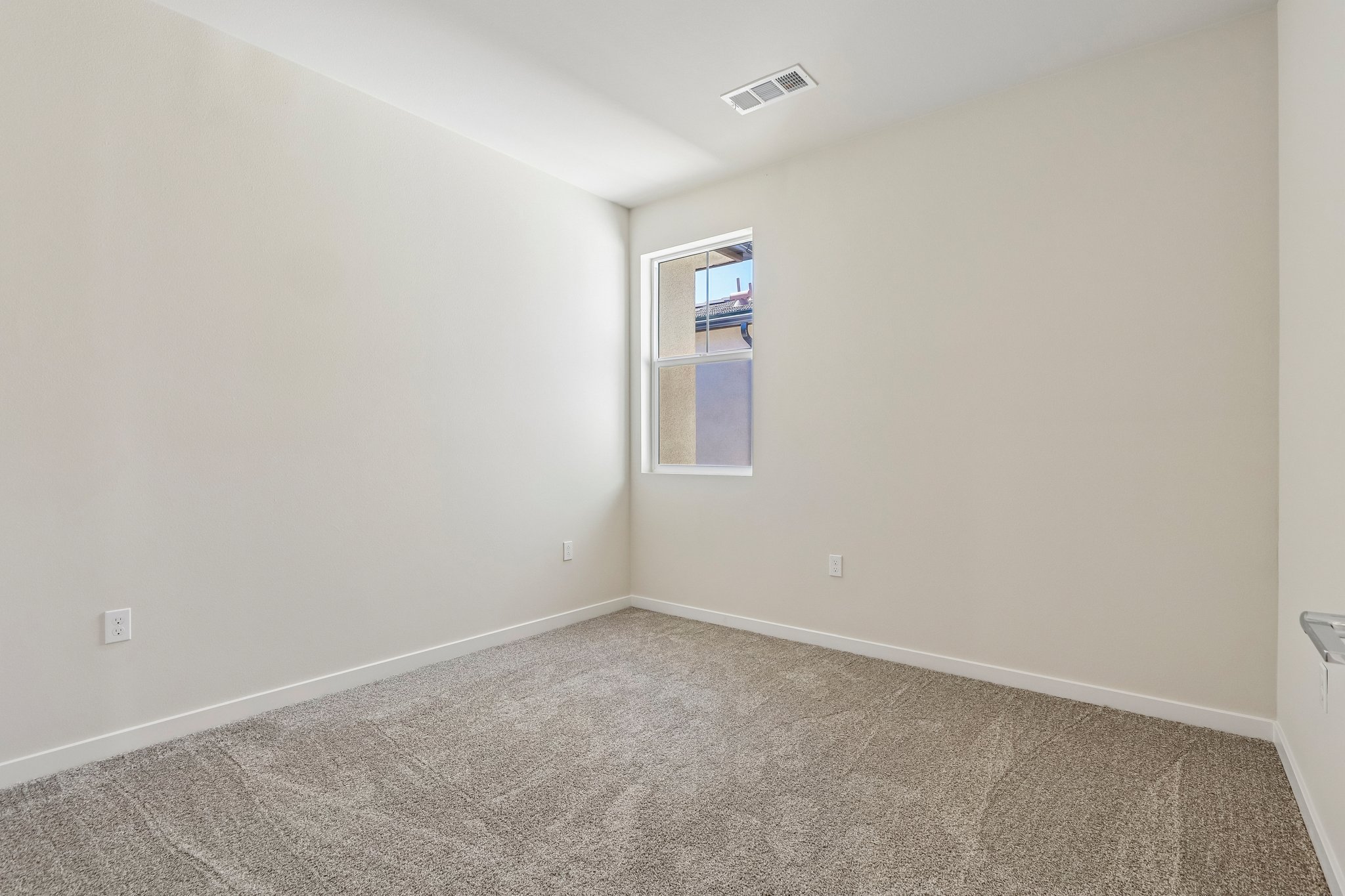A room with a carpet and a window.