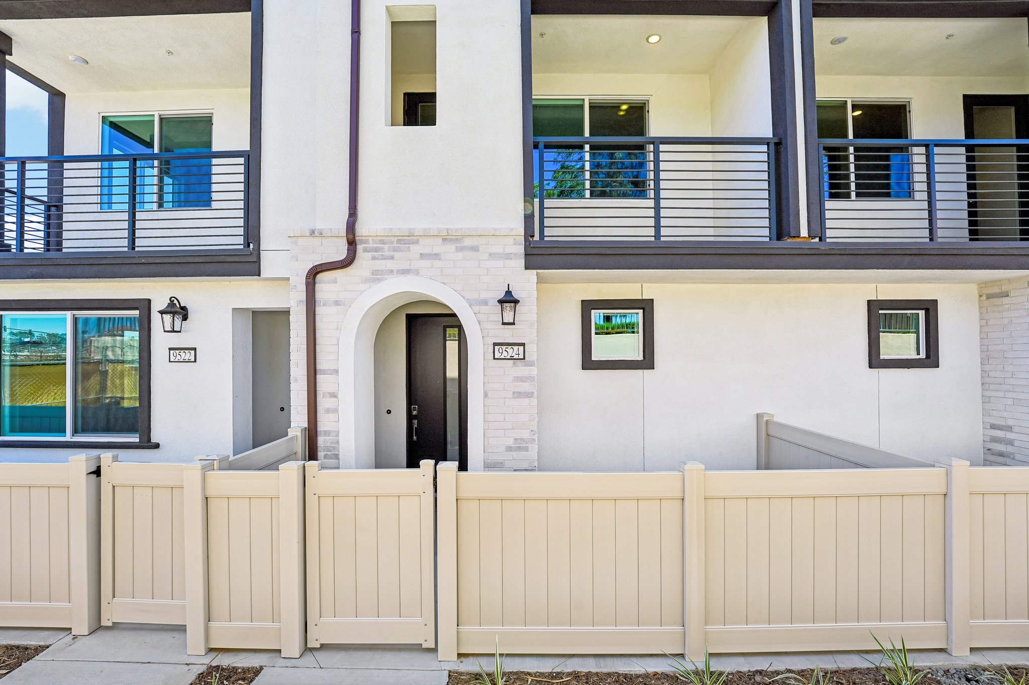 A white building with a white fence.