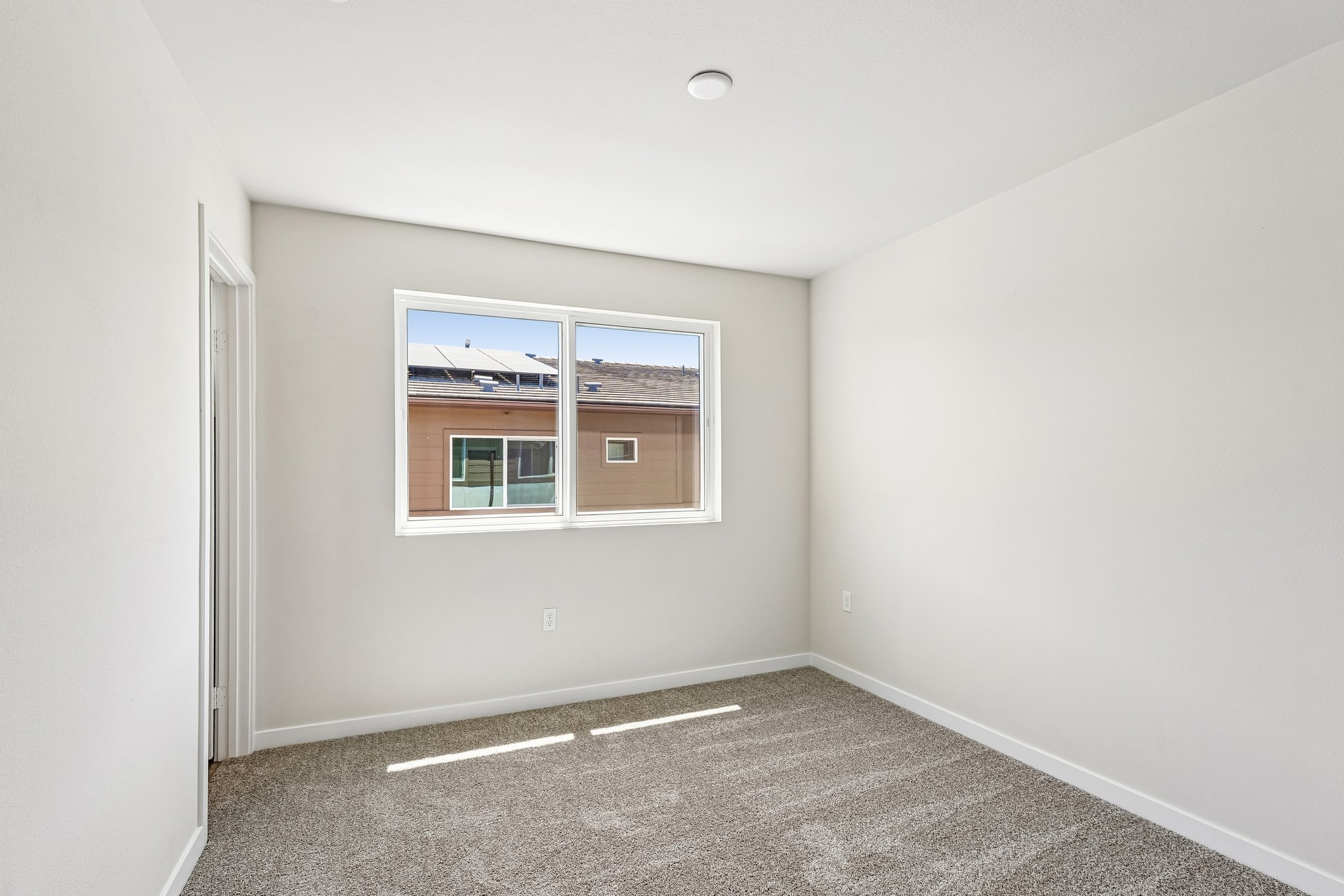 A room with a window and a carpet.