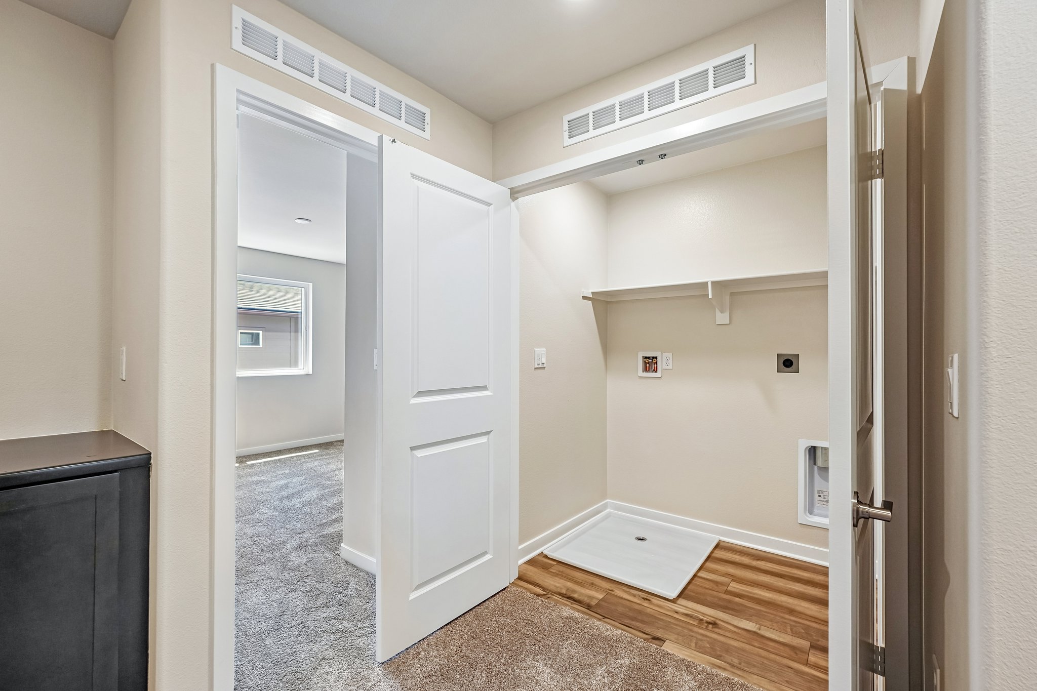A hallway with white cabinets.