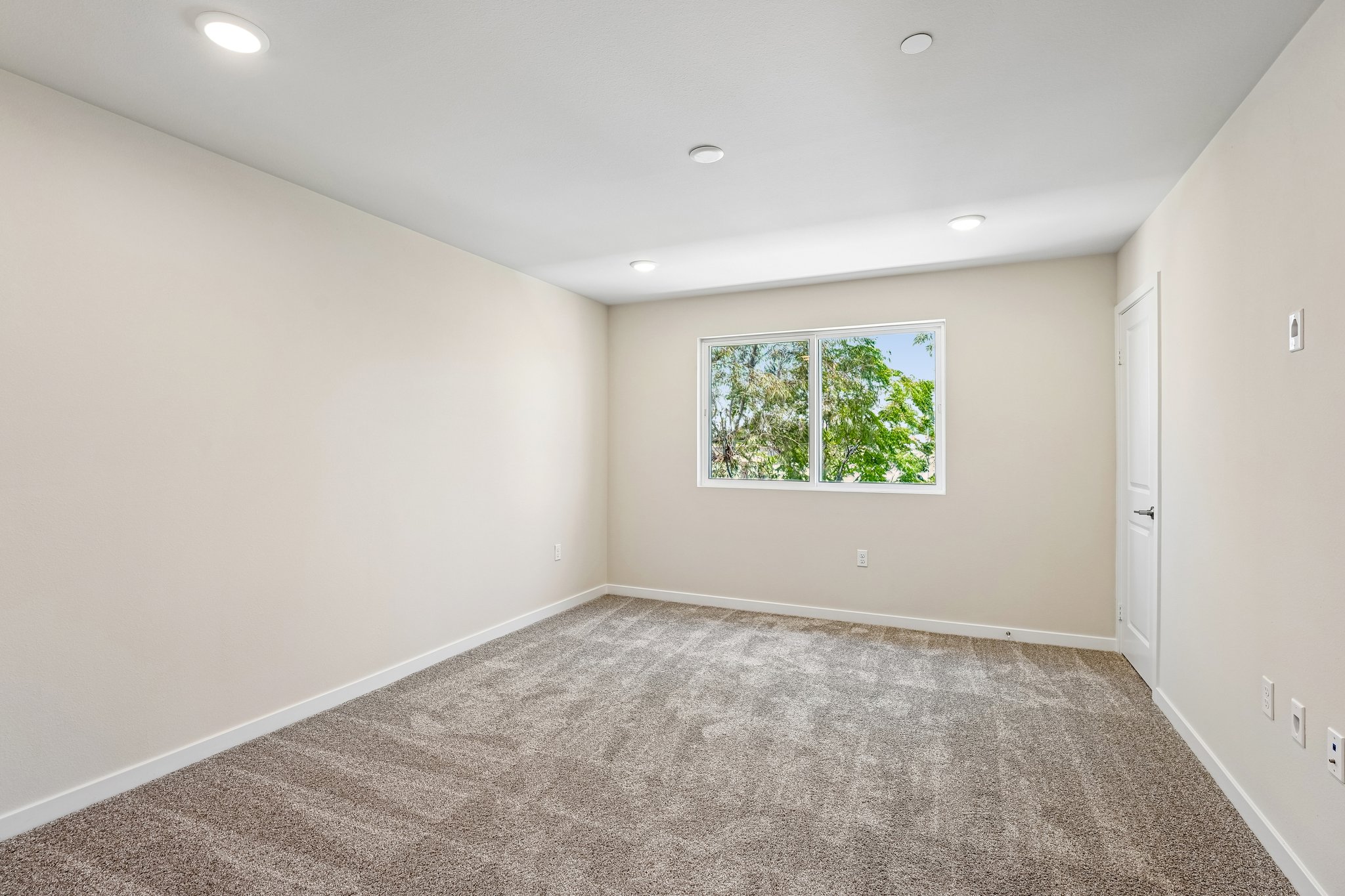 A room with a window and carpet.