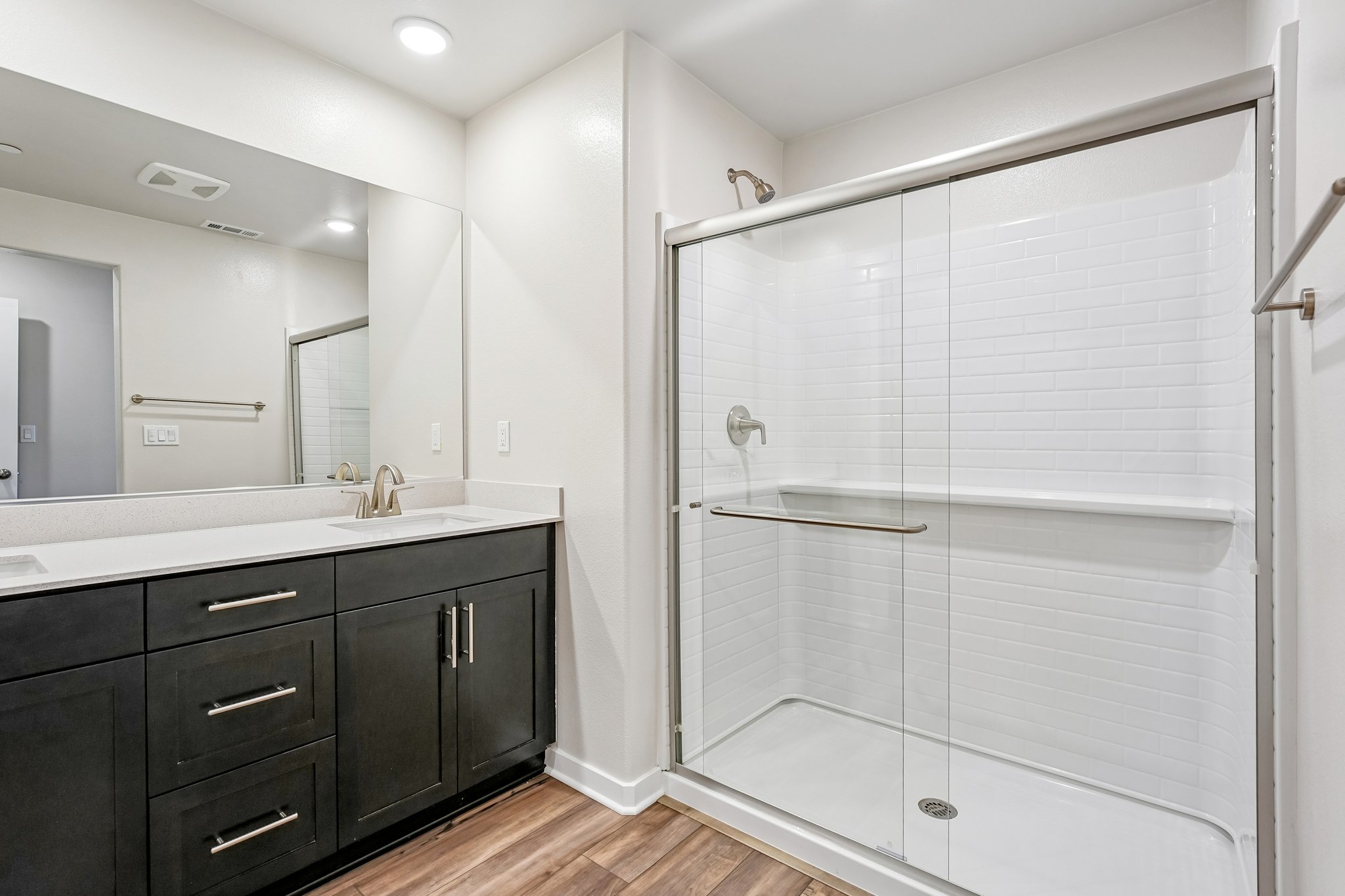 A bathroom with a shower unit and sink.