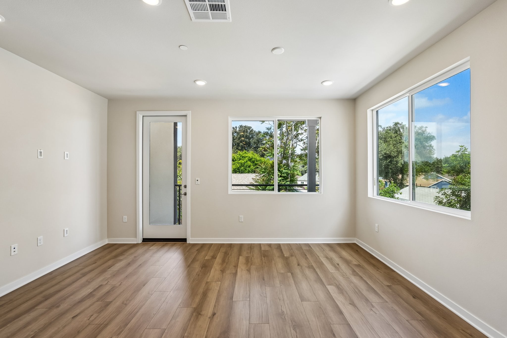 A room with a wood floor and windows.