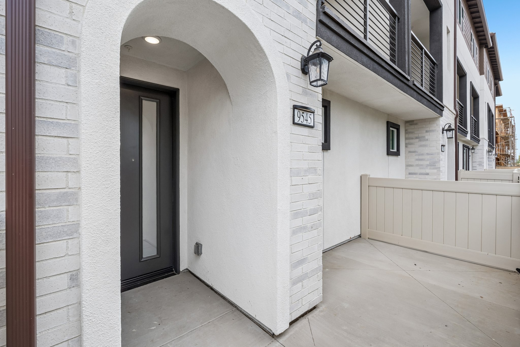 A white building with a white fence.