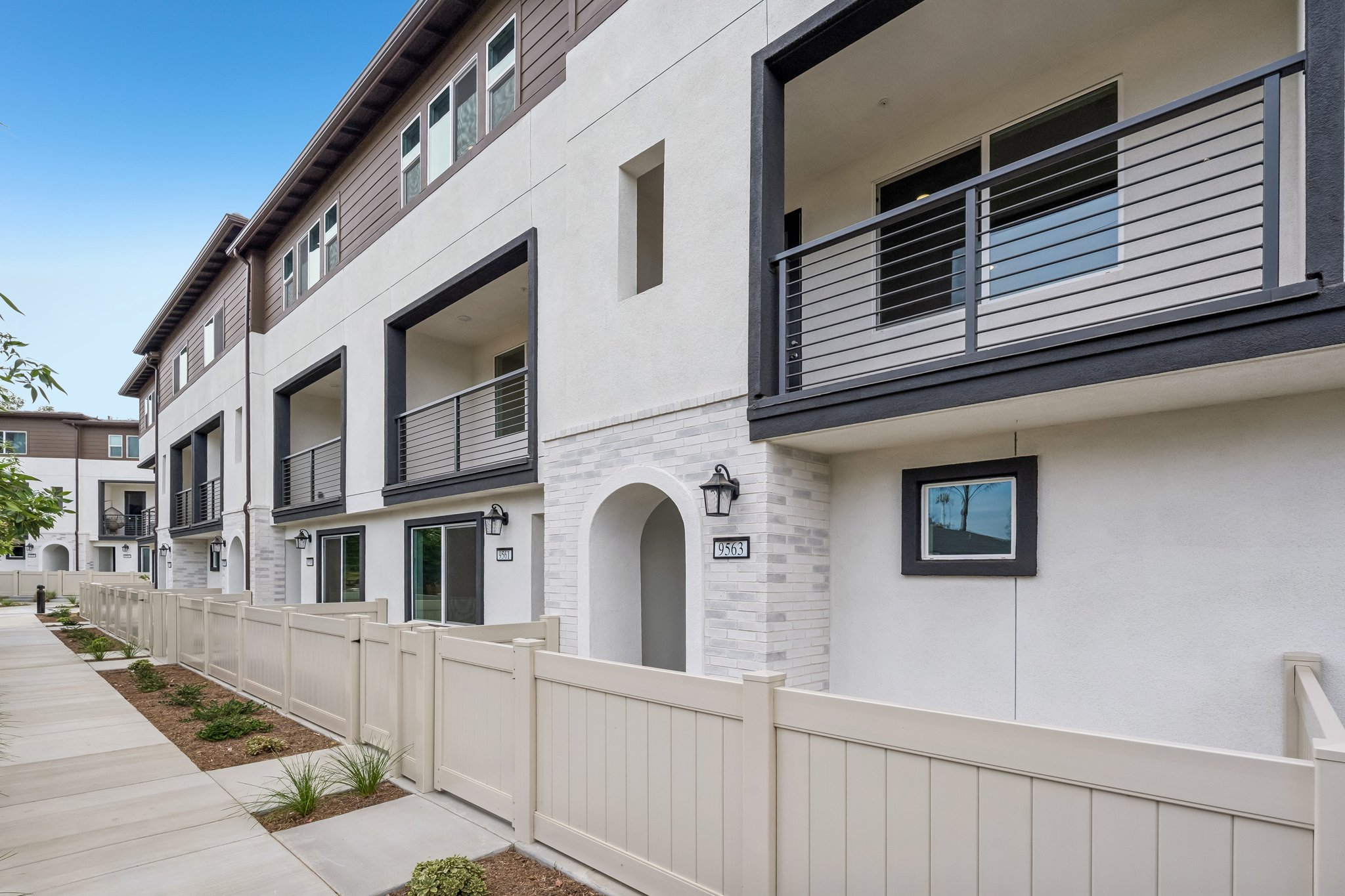 A white building with a white fence.