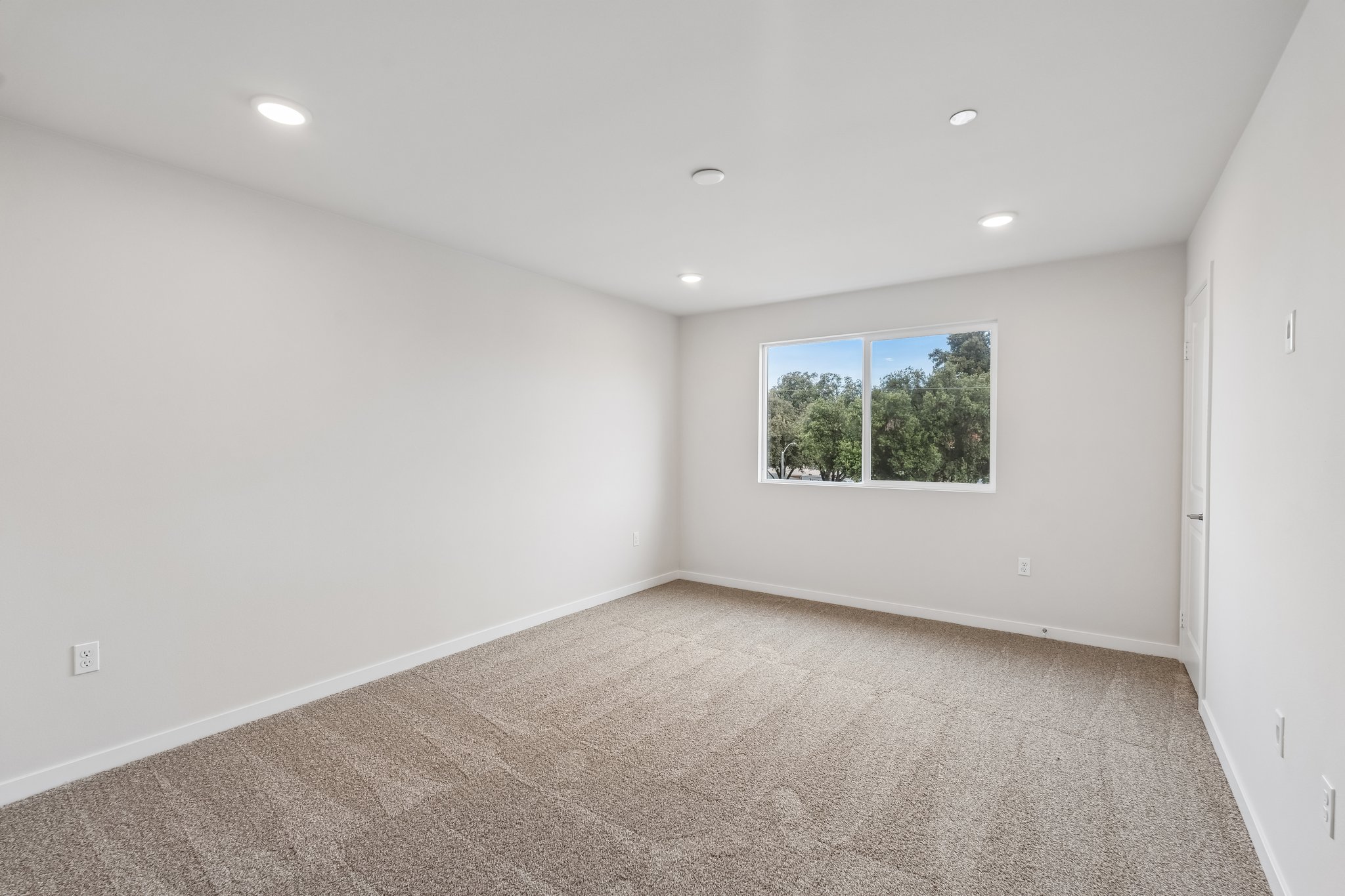 A room with a window and a carpet.