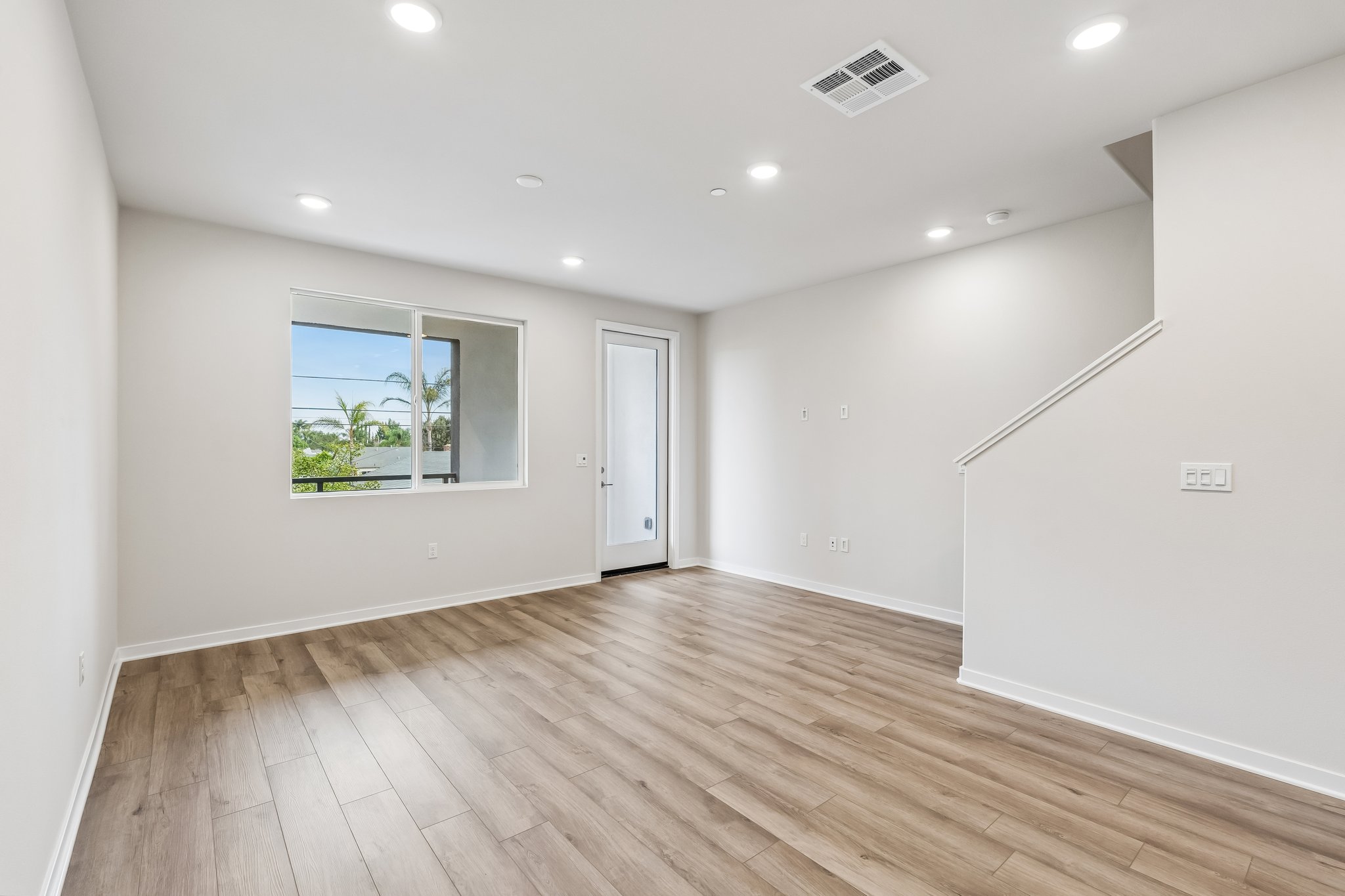 A room with a wood floor and a window.