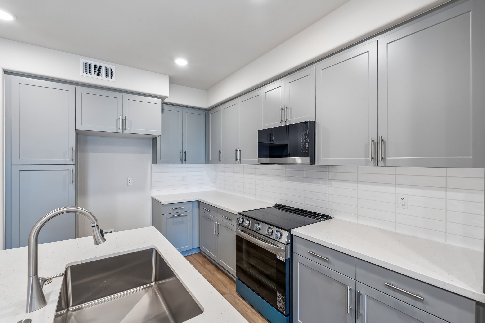 A kitchen with white cabinets.