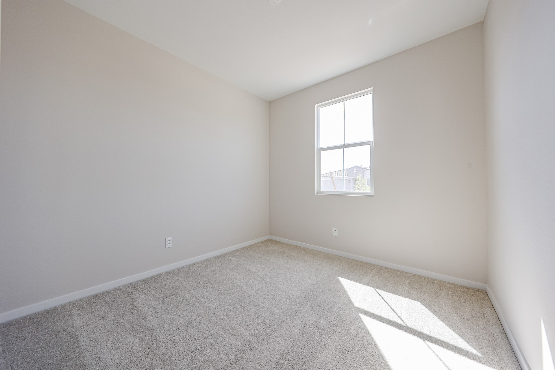 A room with a window and carpet.