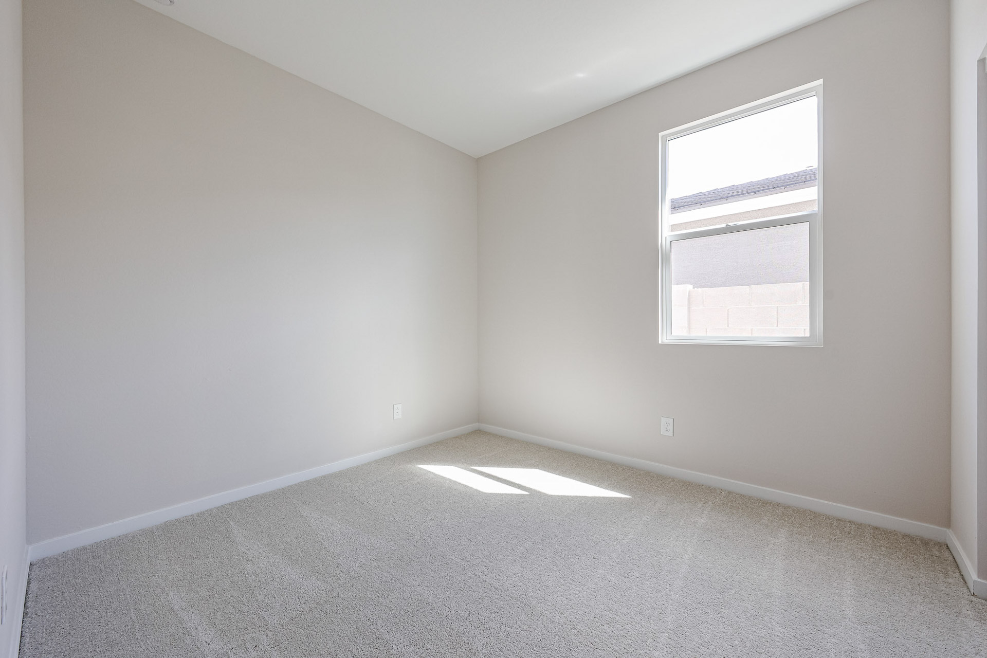 A room with a window and a carpet.