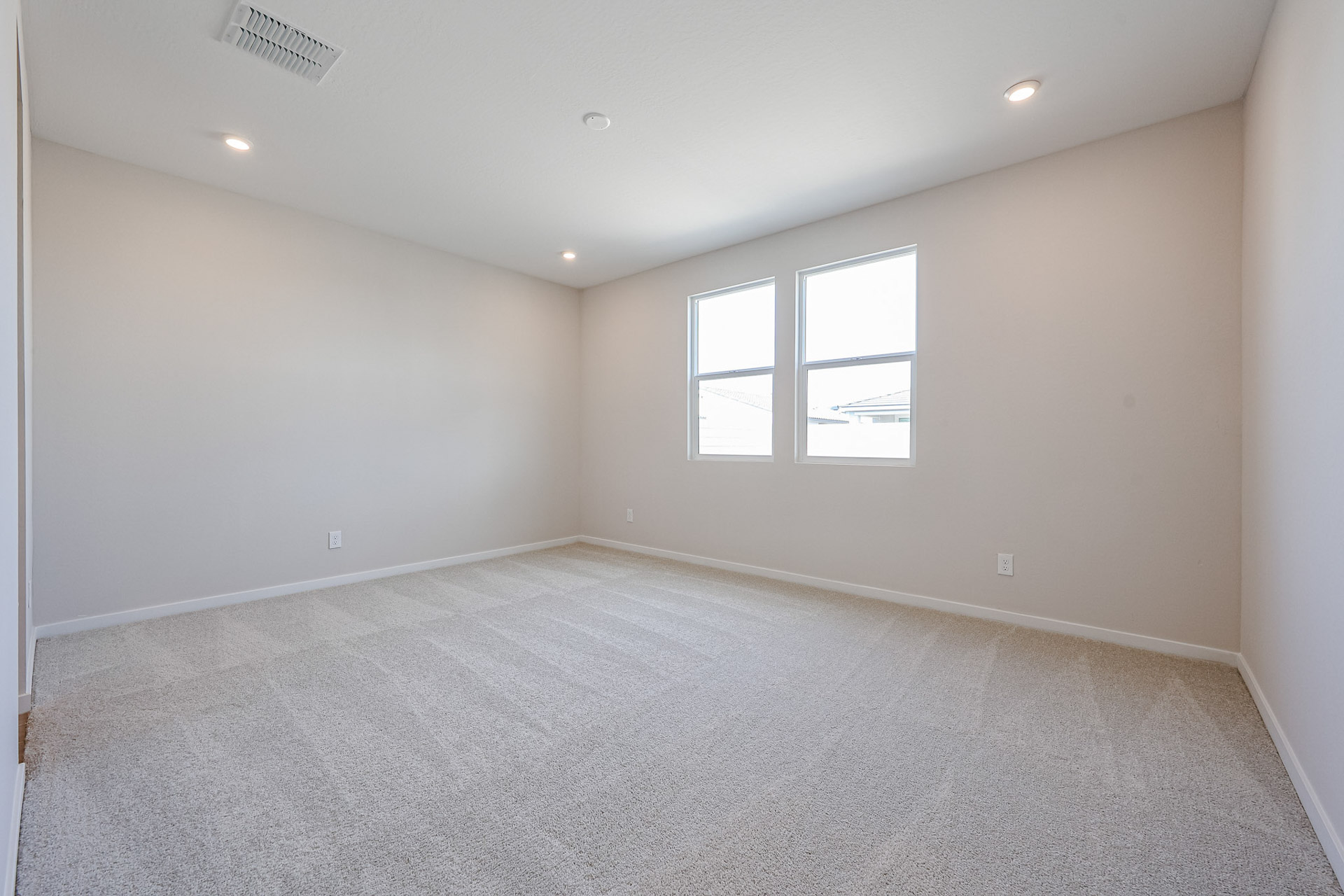A room with a carpet and windows.