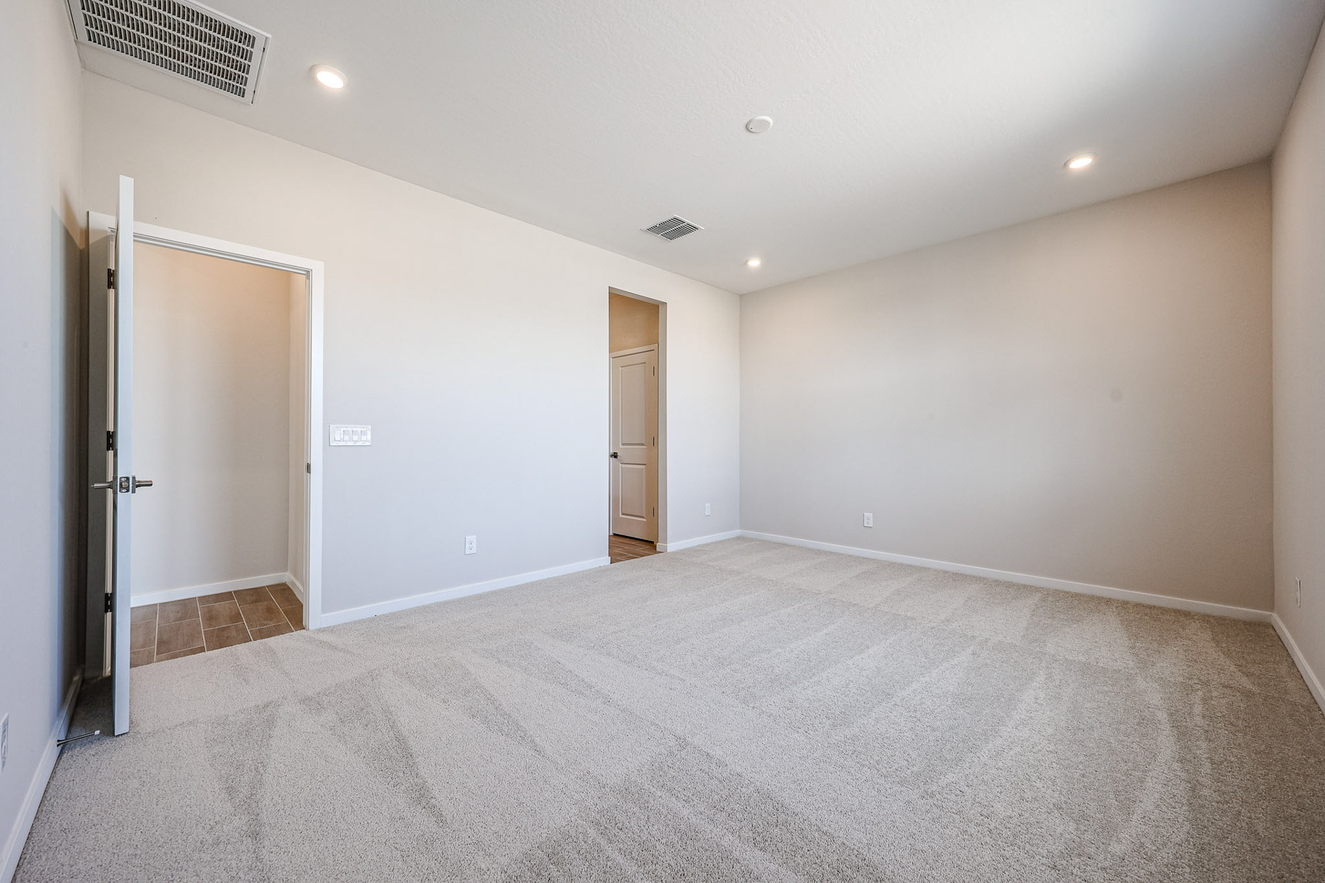 A room with a carpet and doors.