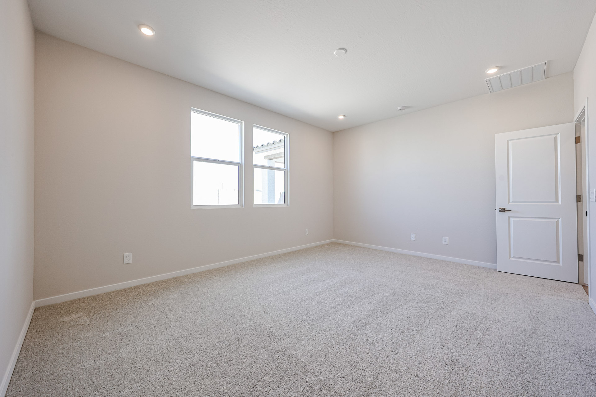 A room with a carpet and windows.
