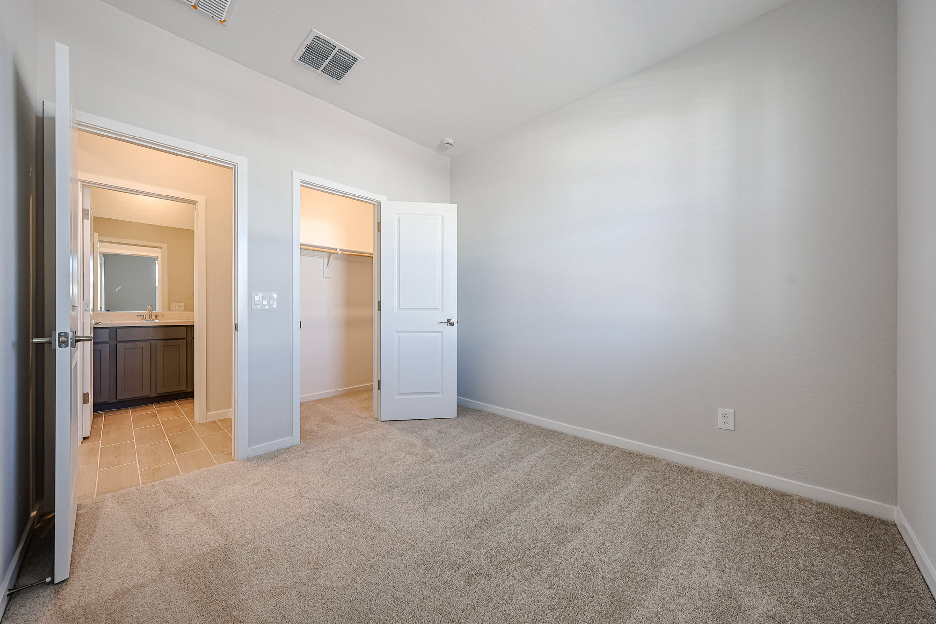 A room with a carpet and a door.