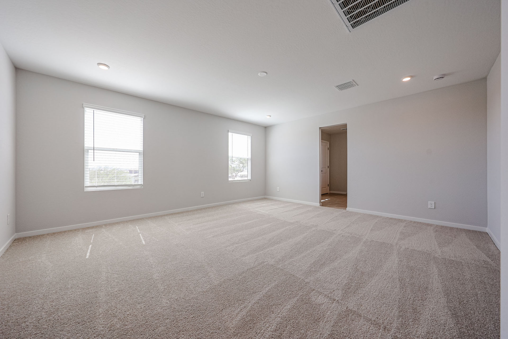 A room with a carpet and a door.
