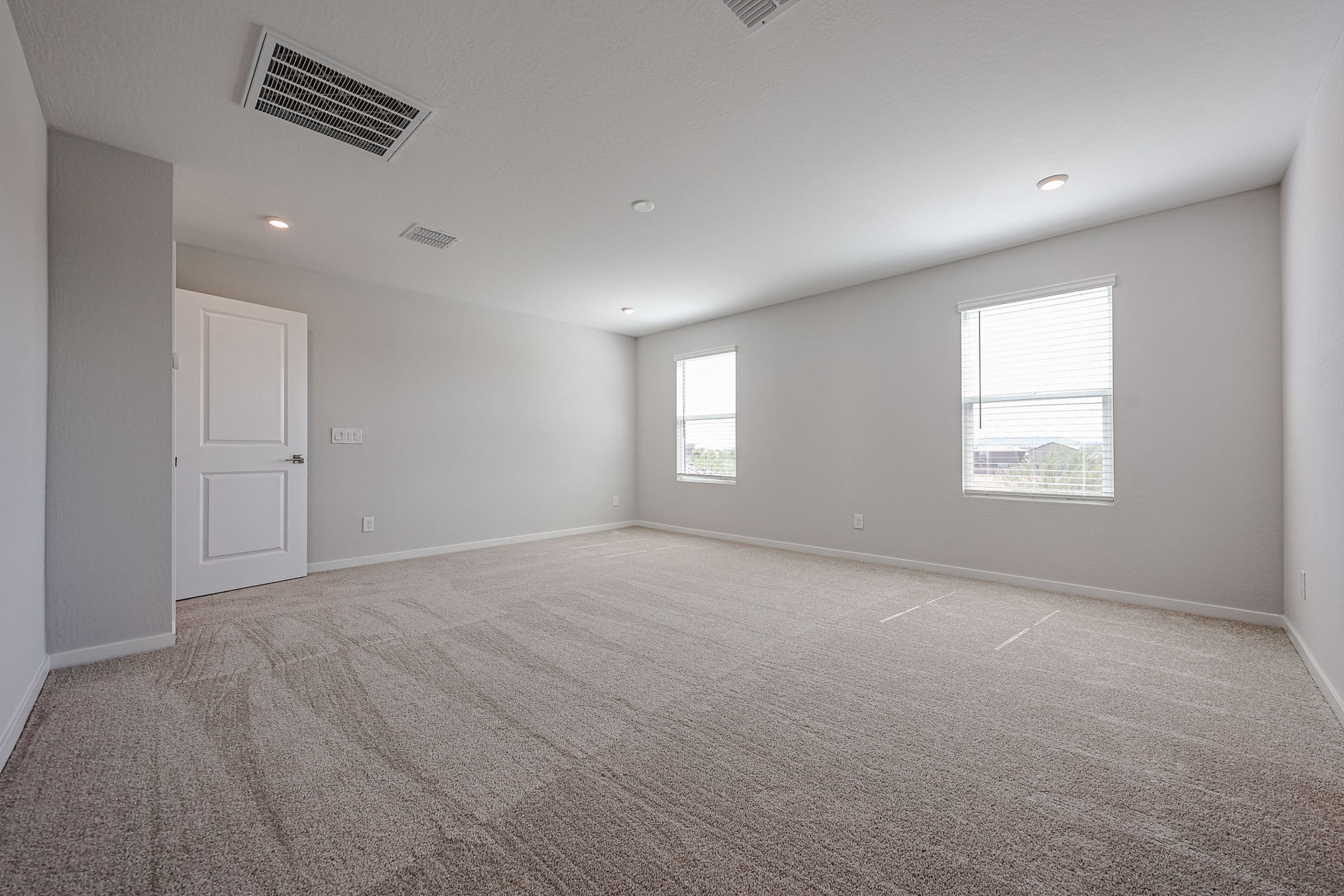 A room with a carpet and a door.