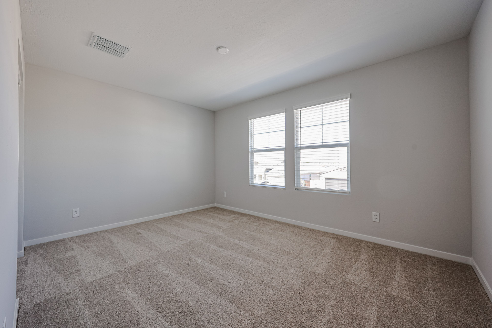 A room with a carpet and windows.