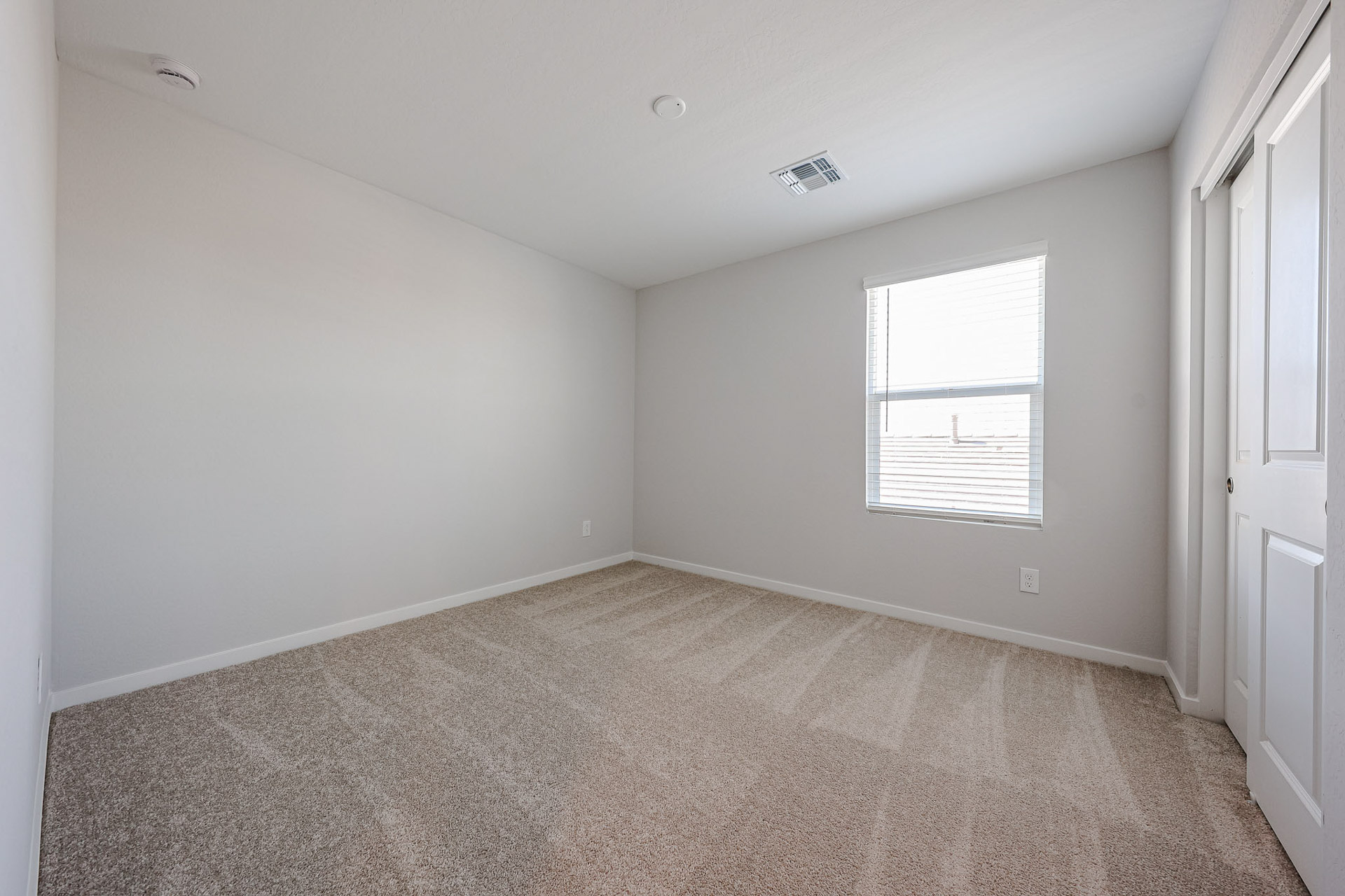 A room with a carpet and a window.