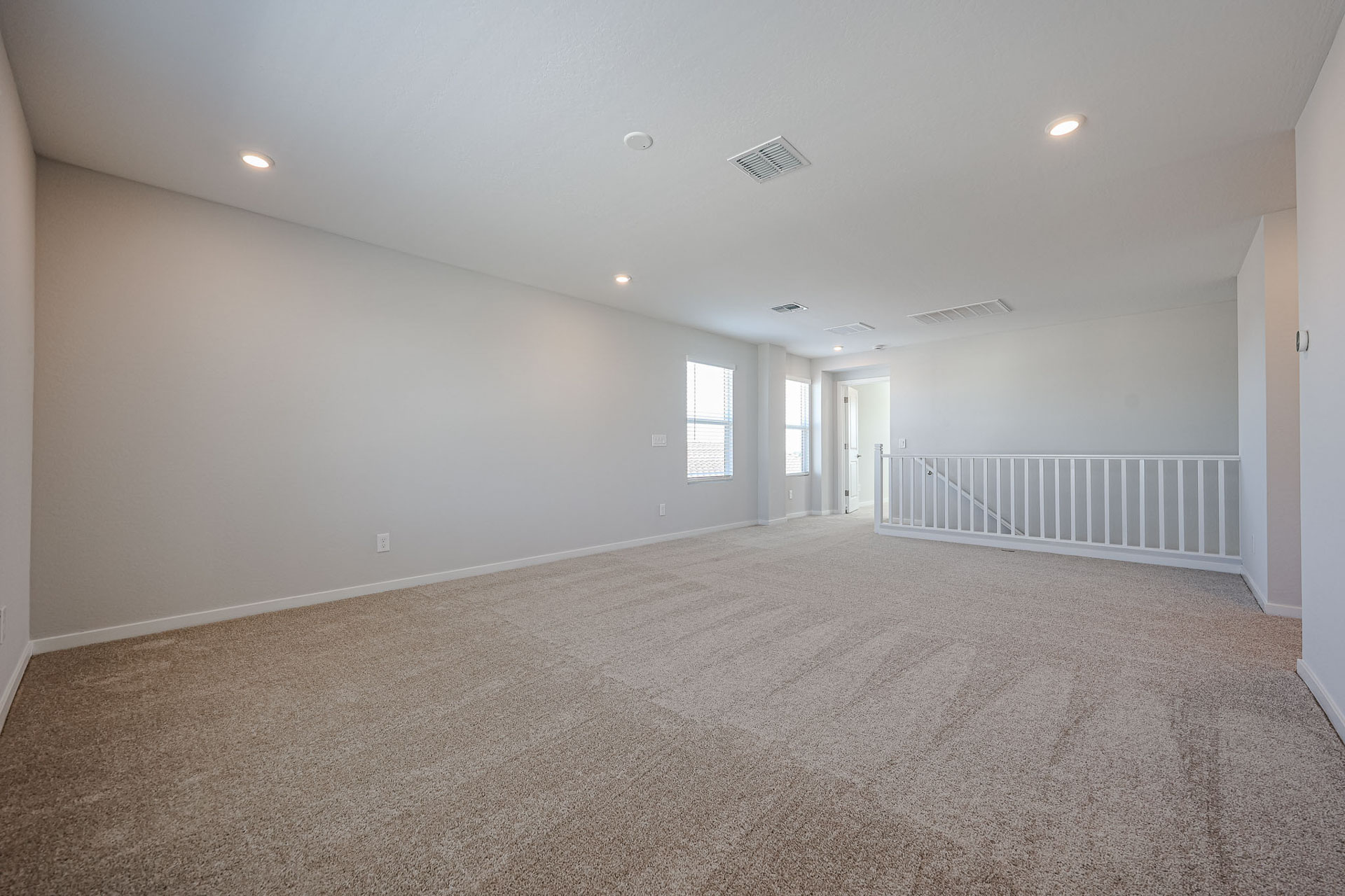A room with a carpet and a railing.
