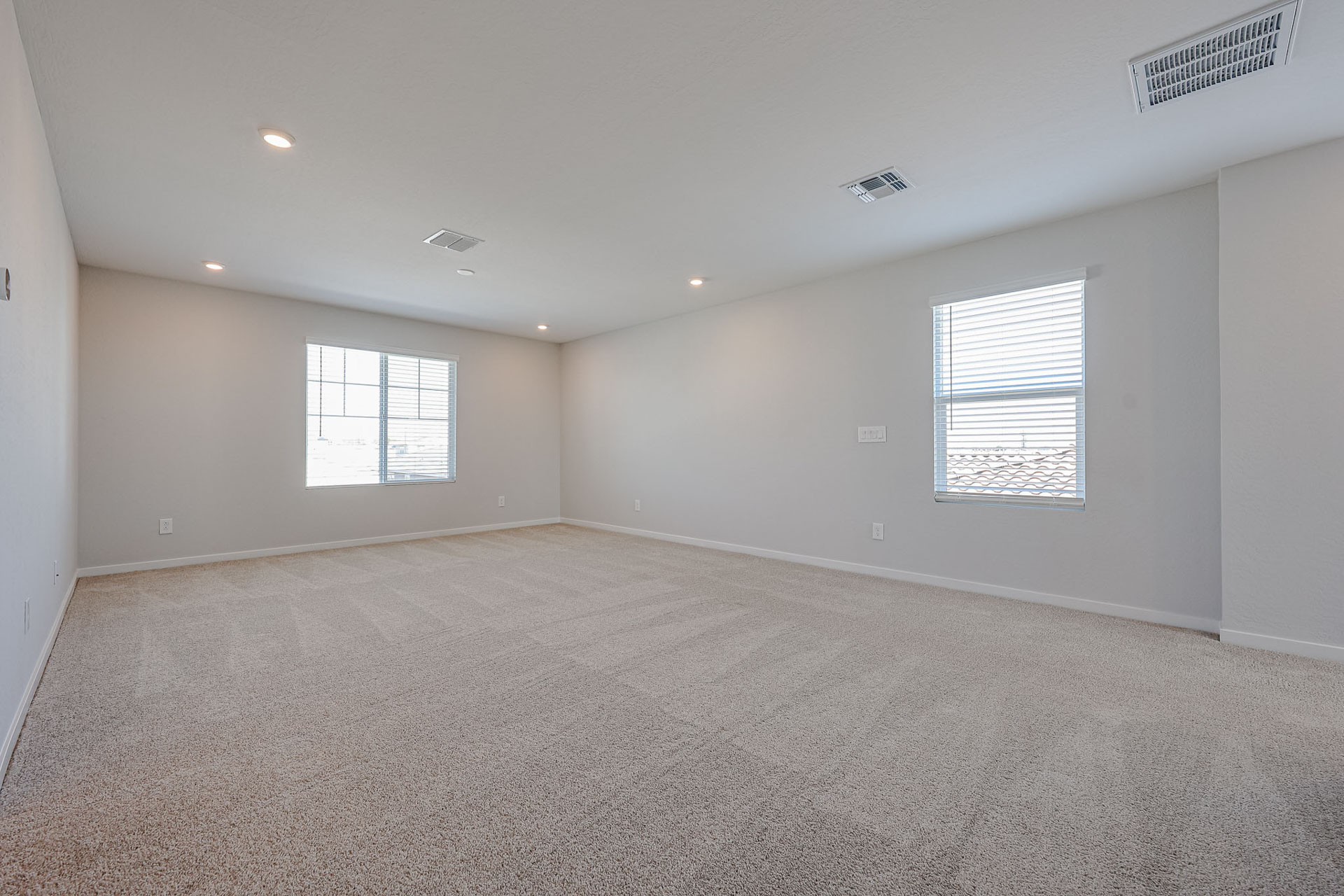 A room with a carpet and windows.
