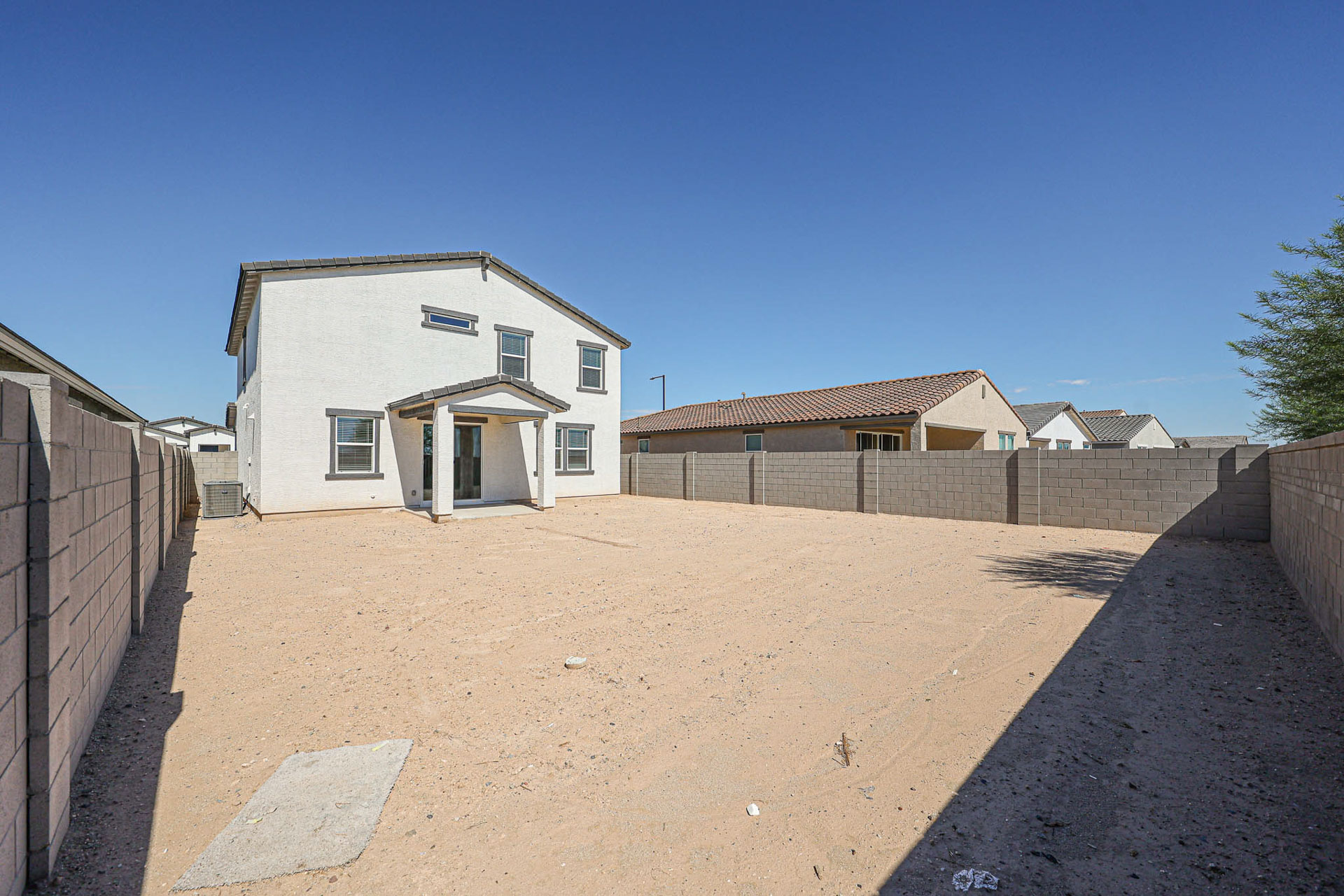 A dirt road with buildings on the side.