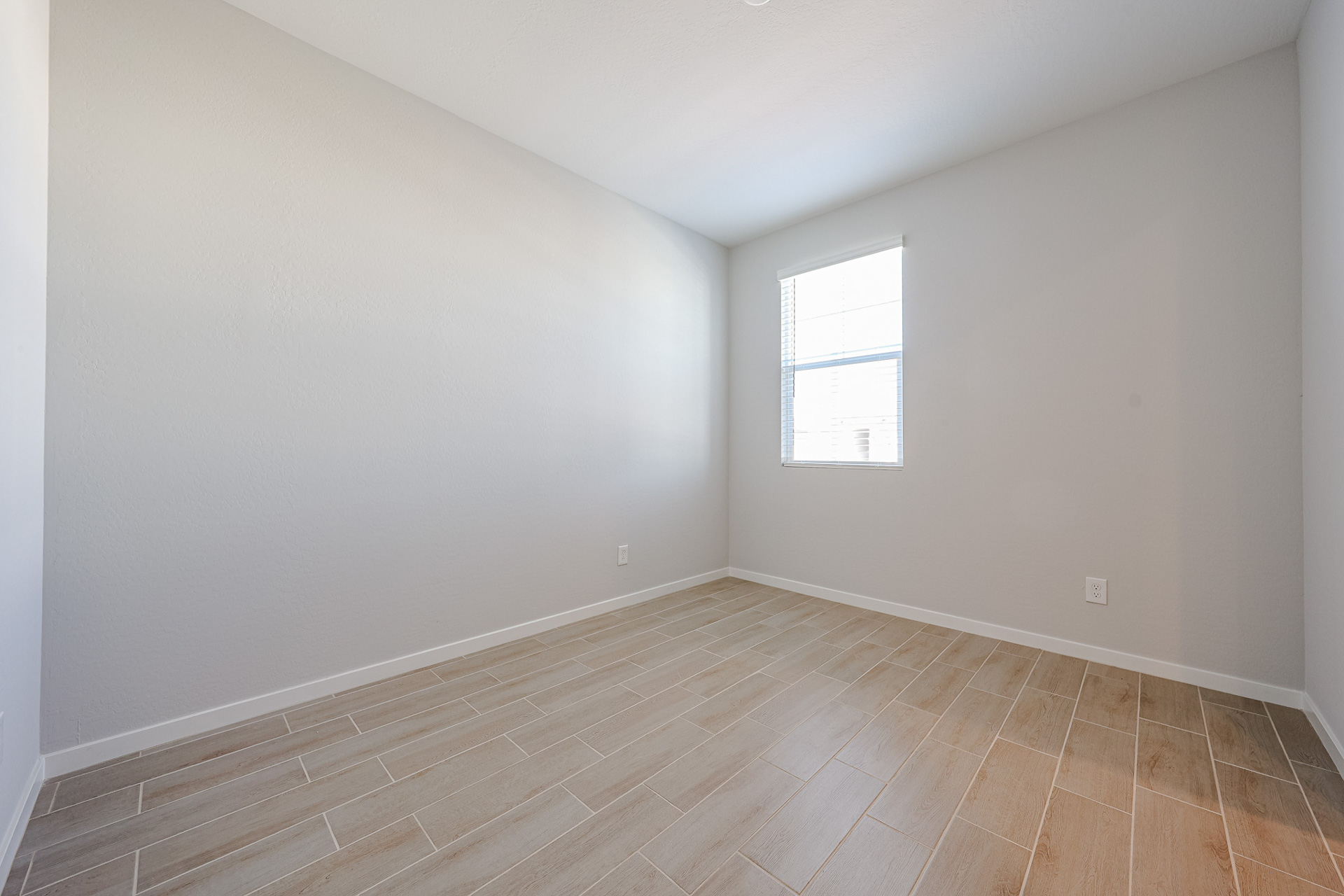 A room with a wood floor and a window.
