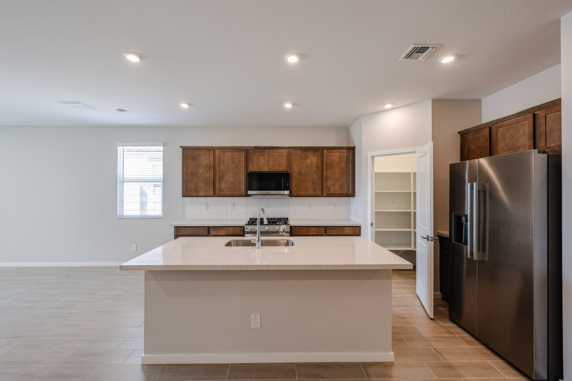 A kitchen with a stainless steel refrigerator.
