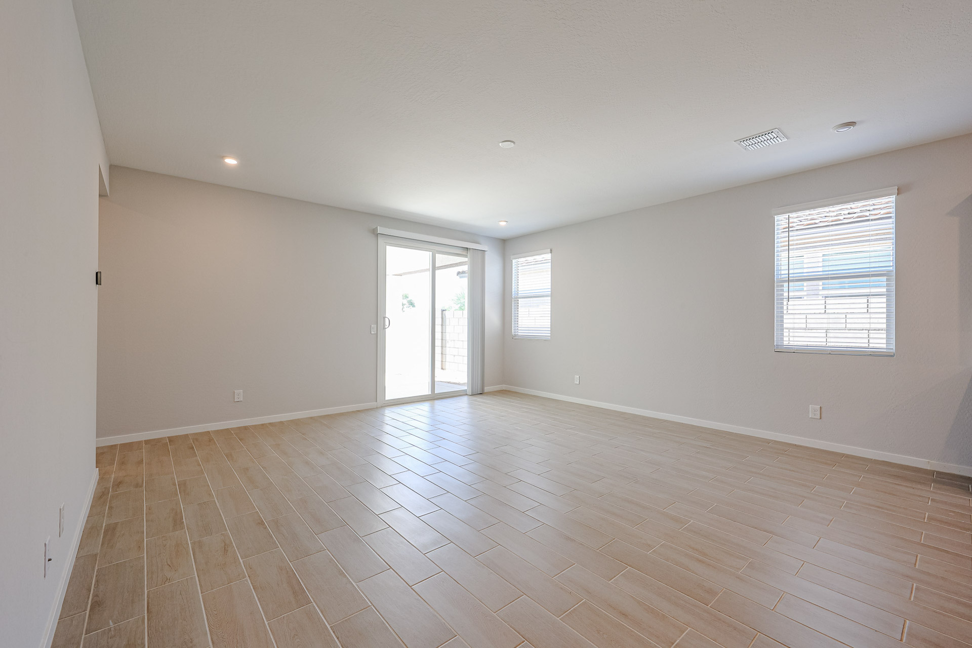 A room with a wood floor and windows.
