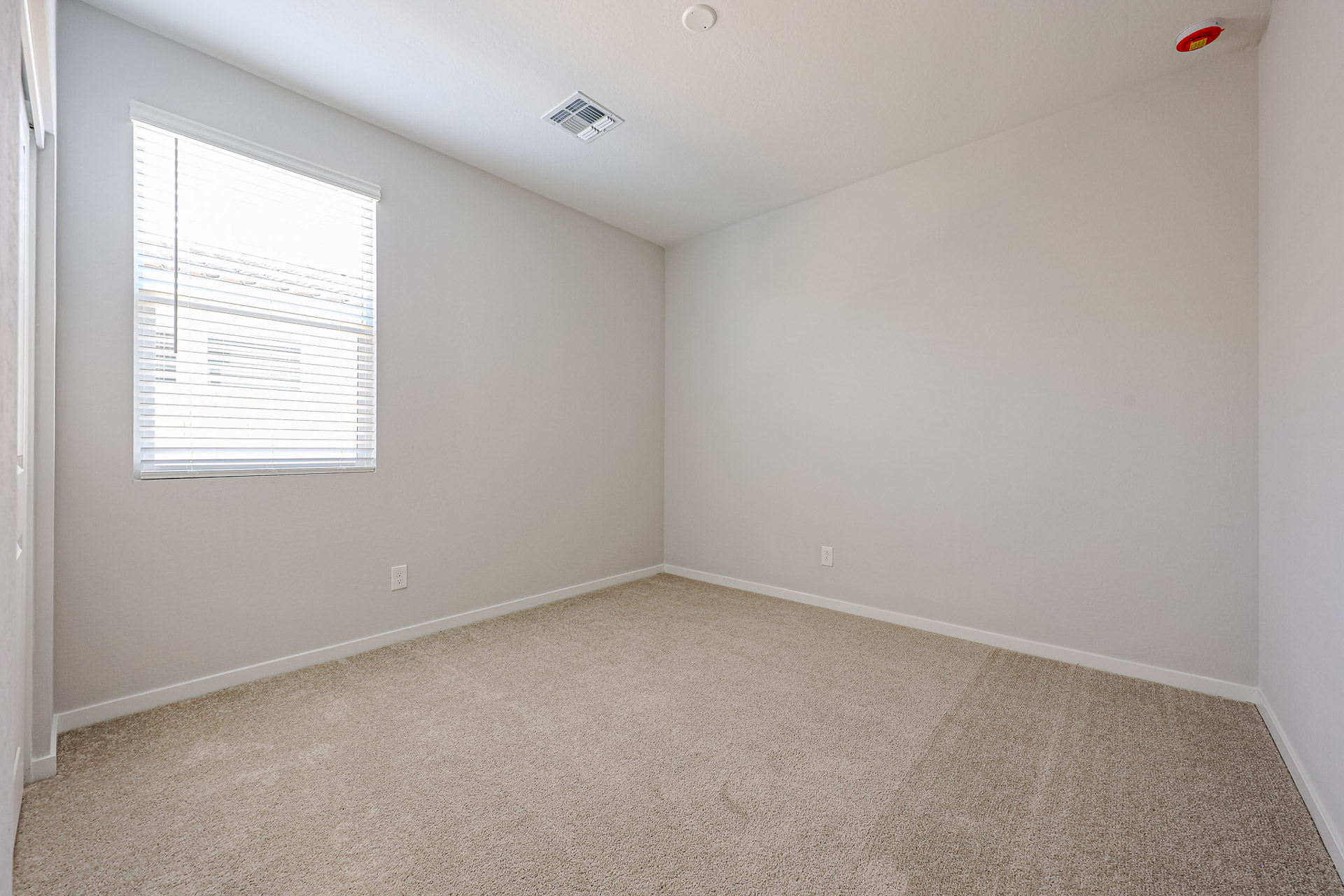 A room with a carpet and a window.