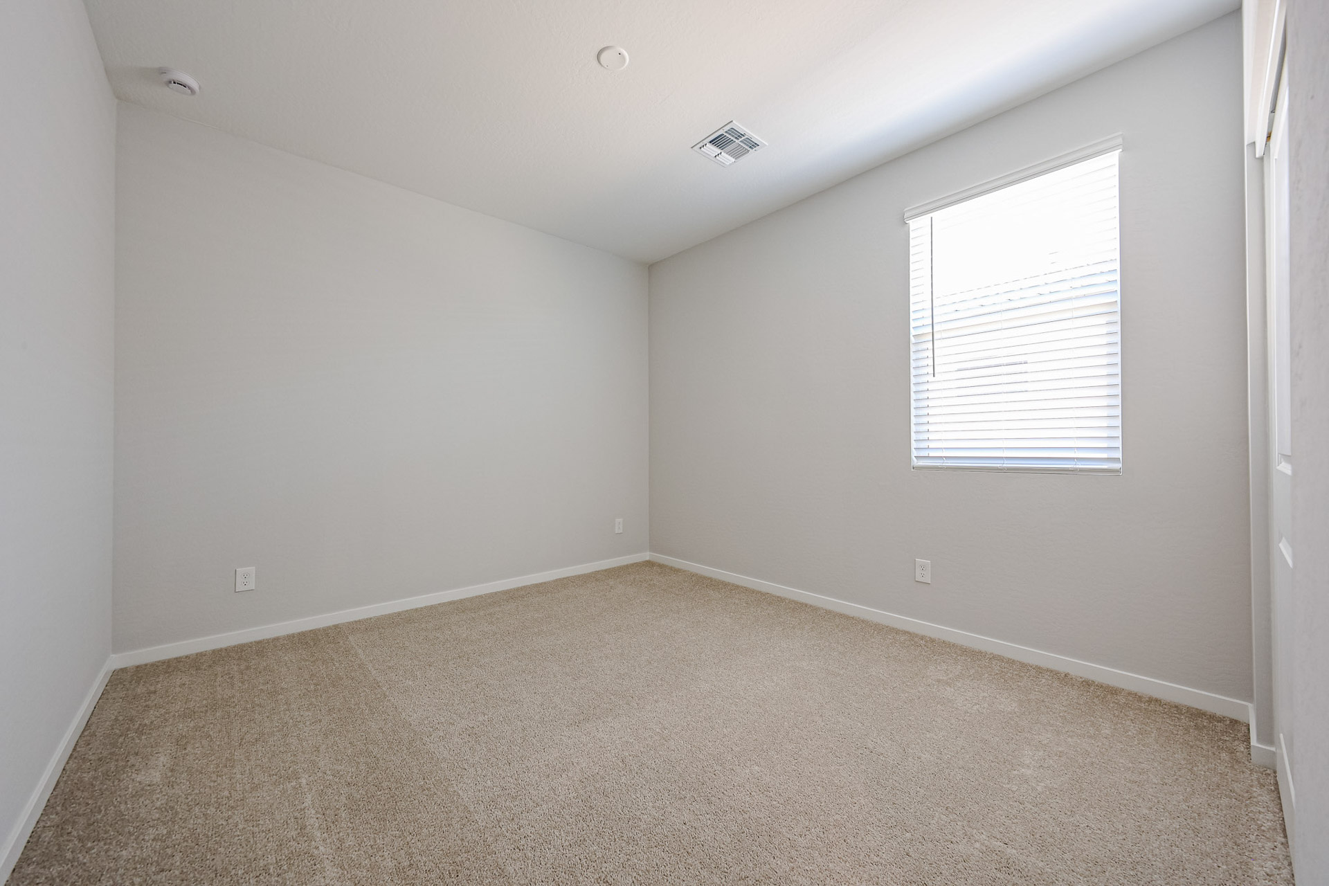 A room with a carpet and a window.