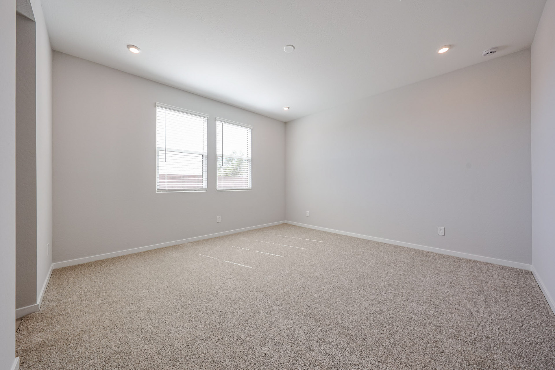 A room with a carpet and windows.