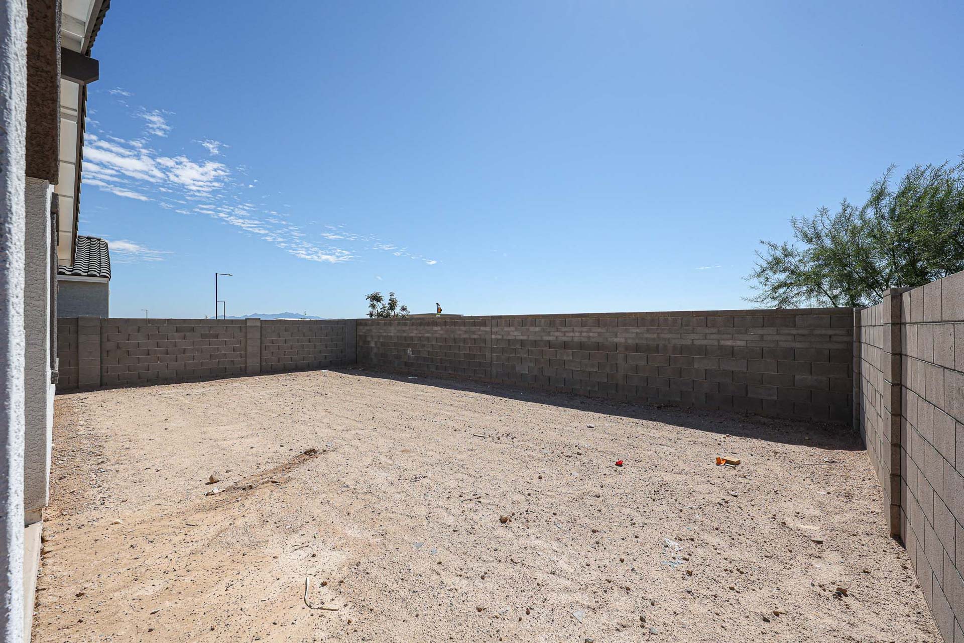 A dirt yard with a brick wall.