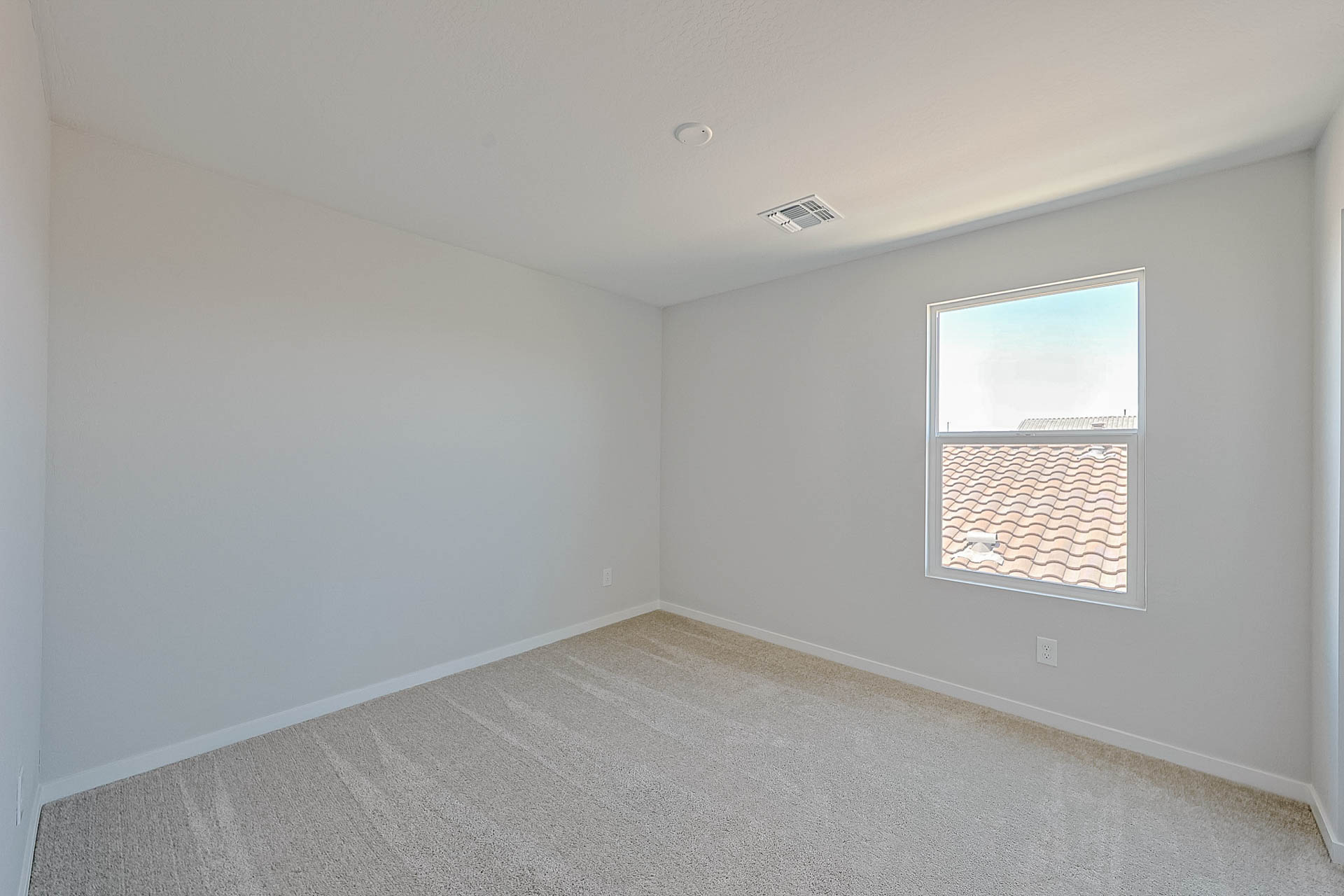 A room with a window and a carpet.