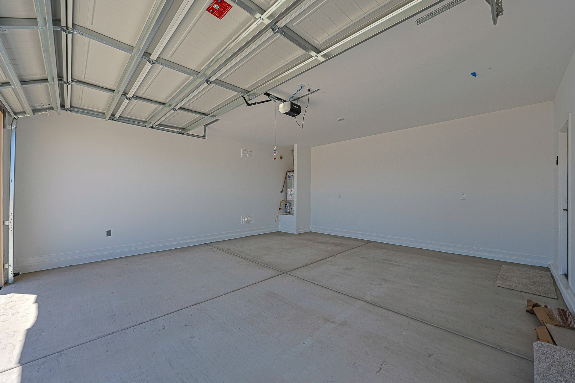 A room with a tile floor and a white wall with a red sign.