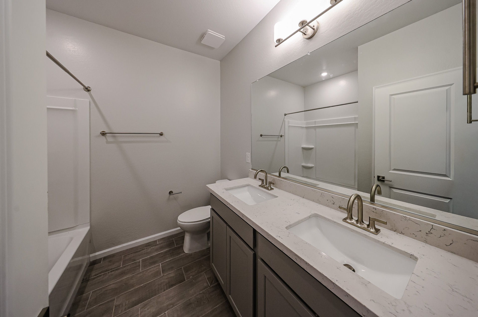 A bathroom with a sink toilet and mirror.
