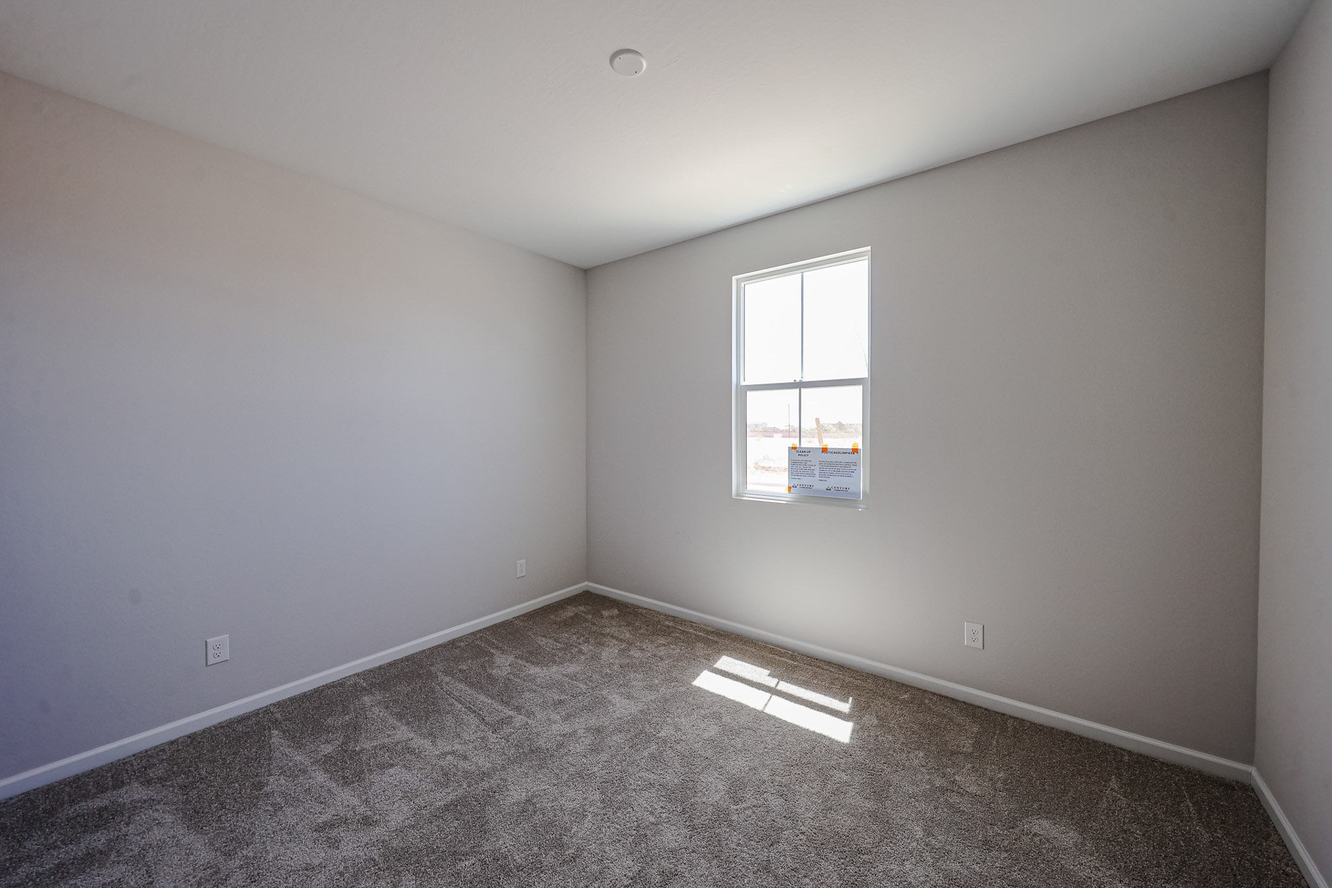 A room with a window and a carpet.