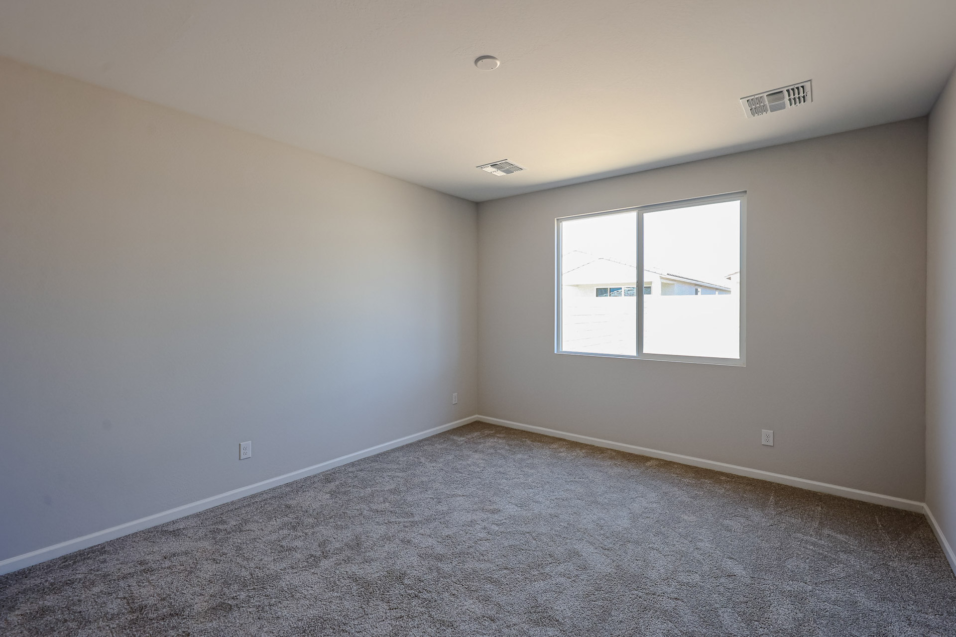 A room with a window and a carpet.