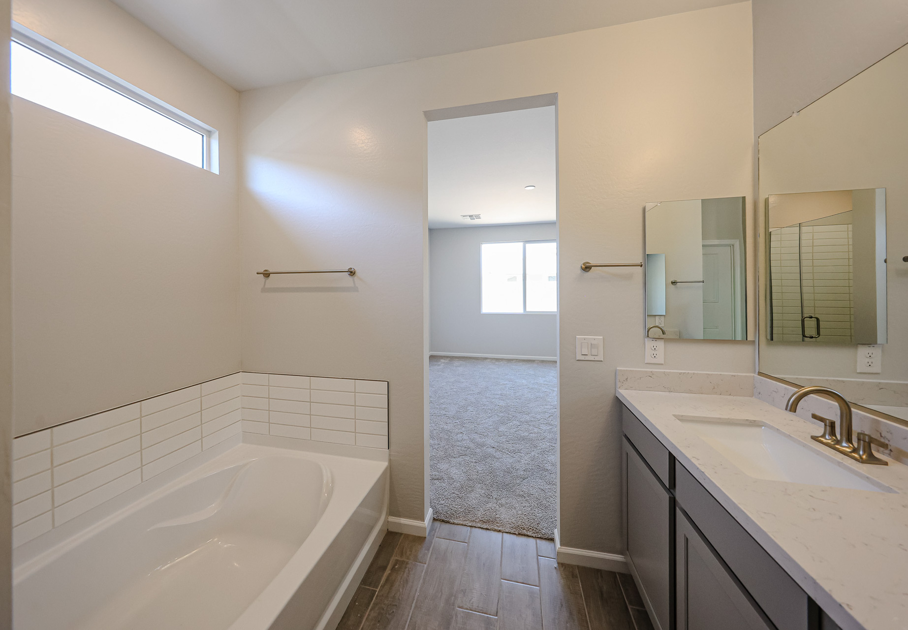 A bathroom with a tub sink and mirror.