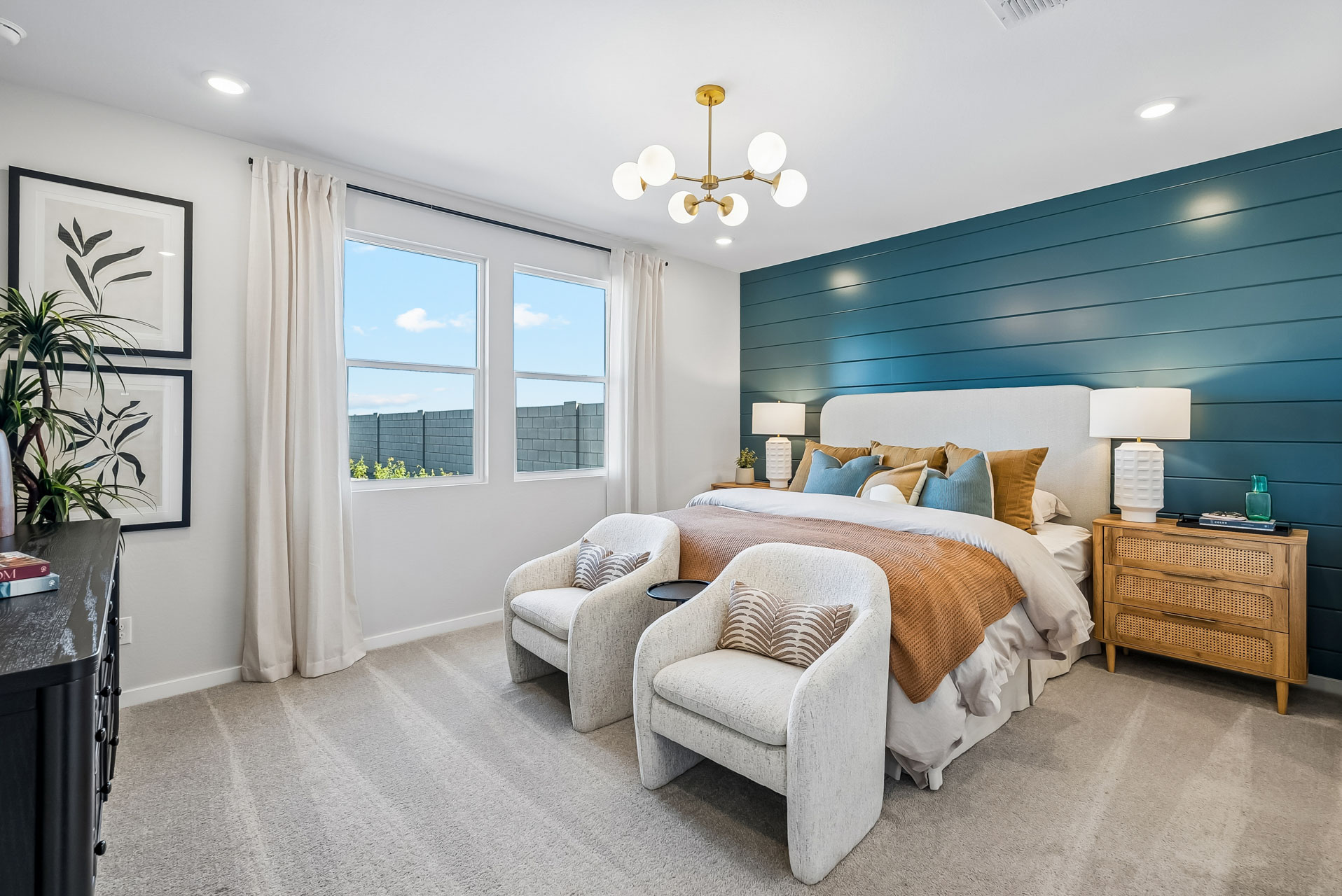 A bedroom with a bed and chairs.